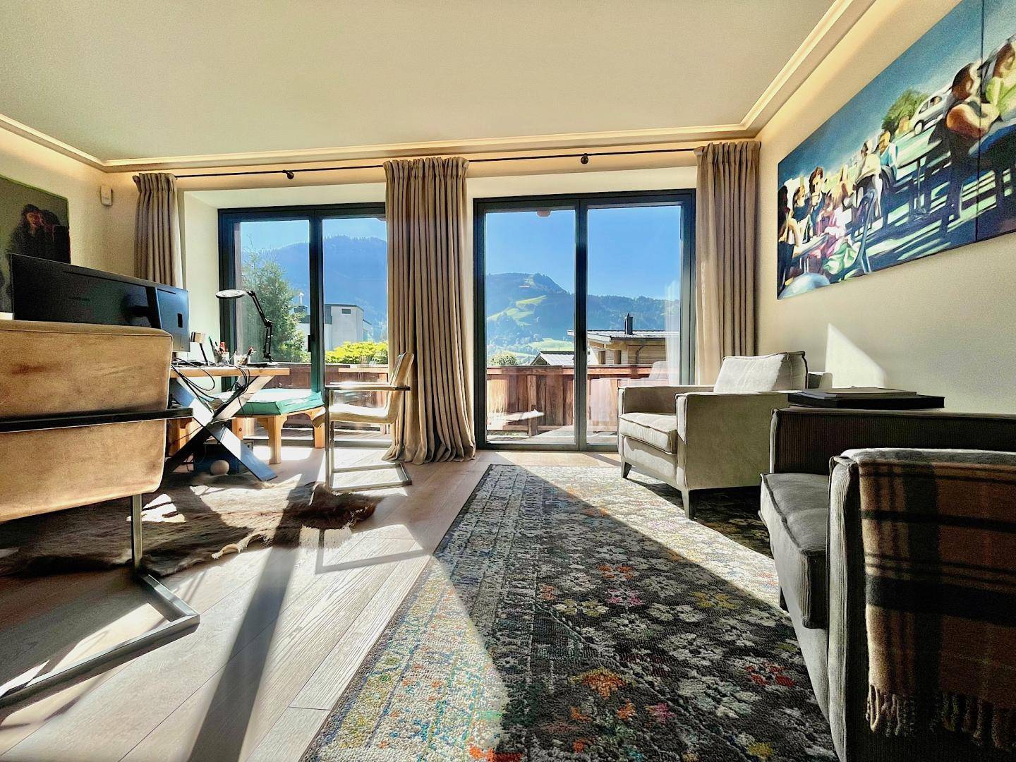 Helles Arbeitszimmer mit großen Fenstern, Holzboden und inspirierendem Bergblick.
