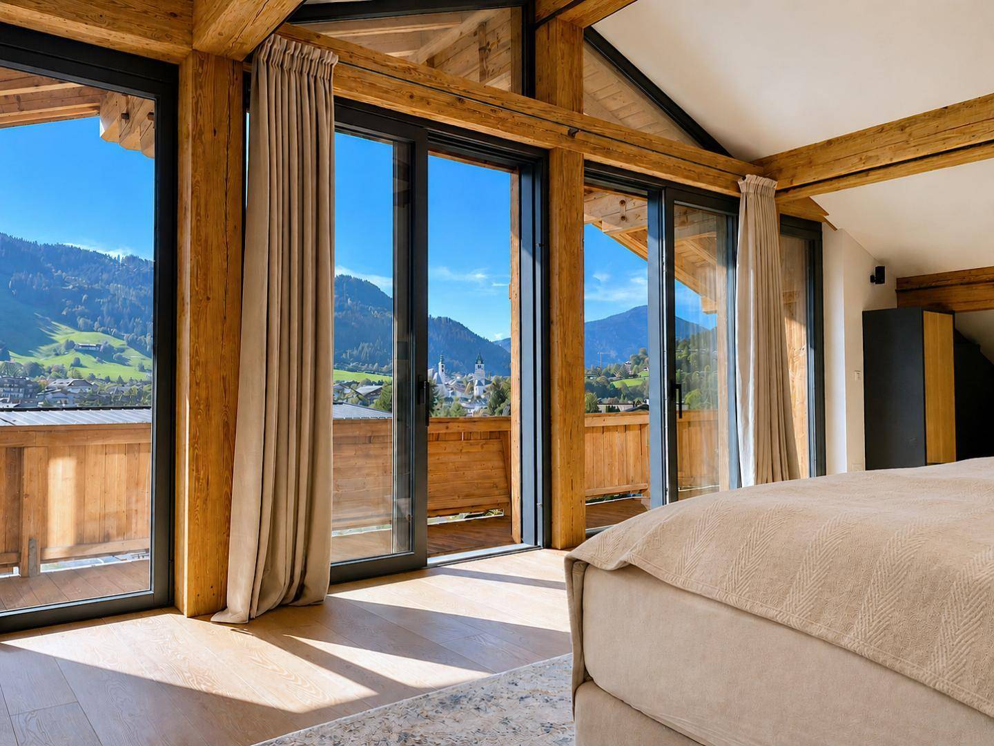 Helles Schlafzimmer mit bodentiefen Fenstern, Holzbalken und atemberaubendem Bergblick.