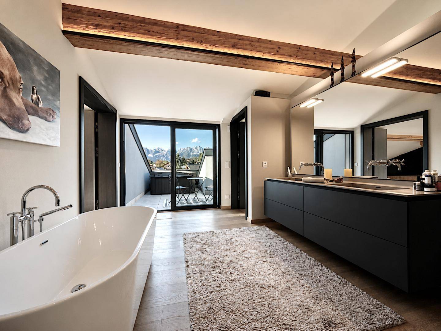 Luxuriöses Badezimmer mit freistehender Badewanne, Doppelwaschbecken und Balkonzugang mit Whirlpool.