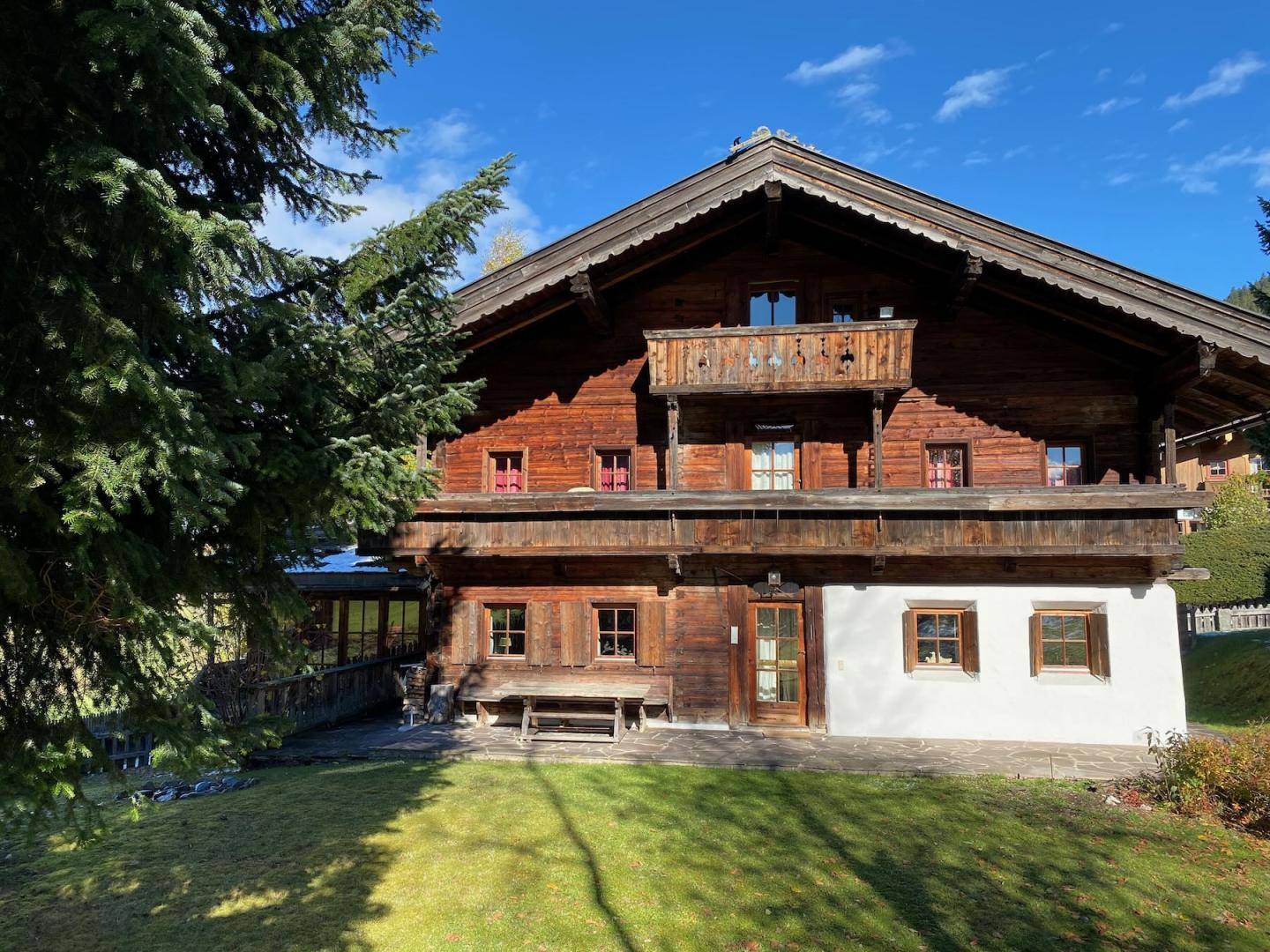Detailansicht der Holzfassade eines traditionellen alpinen Hauses mit Balkonen und Fenstern.