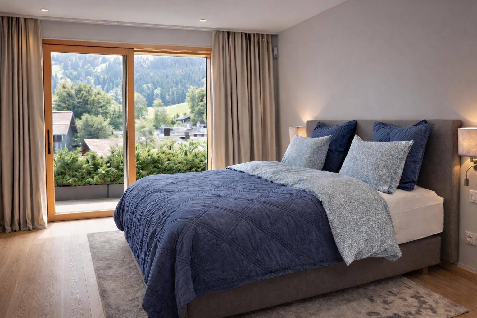 Helles Schlafzimmer mit bequemen Bett und weitem Ausblick auf die umliegende Berglandschaft.