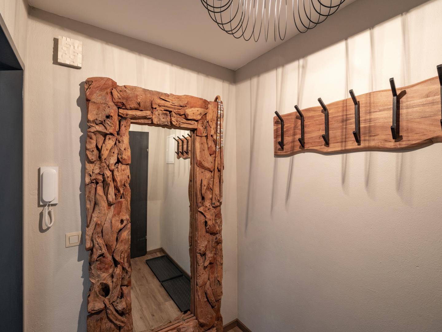 Eingangsbereich mit großem Holzspiegel und Garderobe, bietet rustikale und funktionale Elemente.