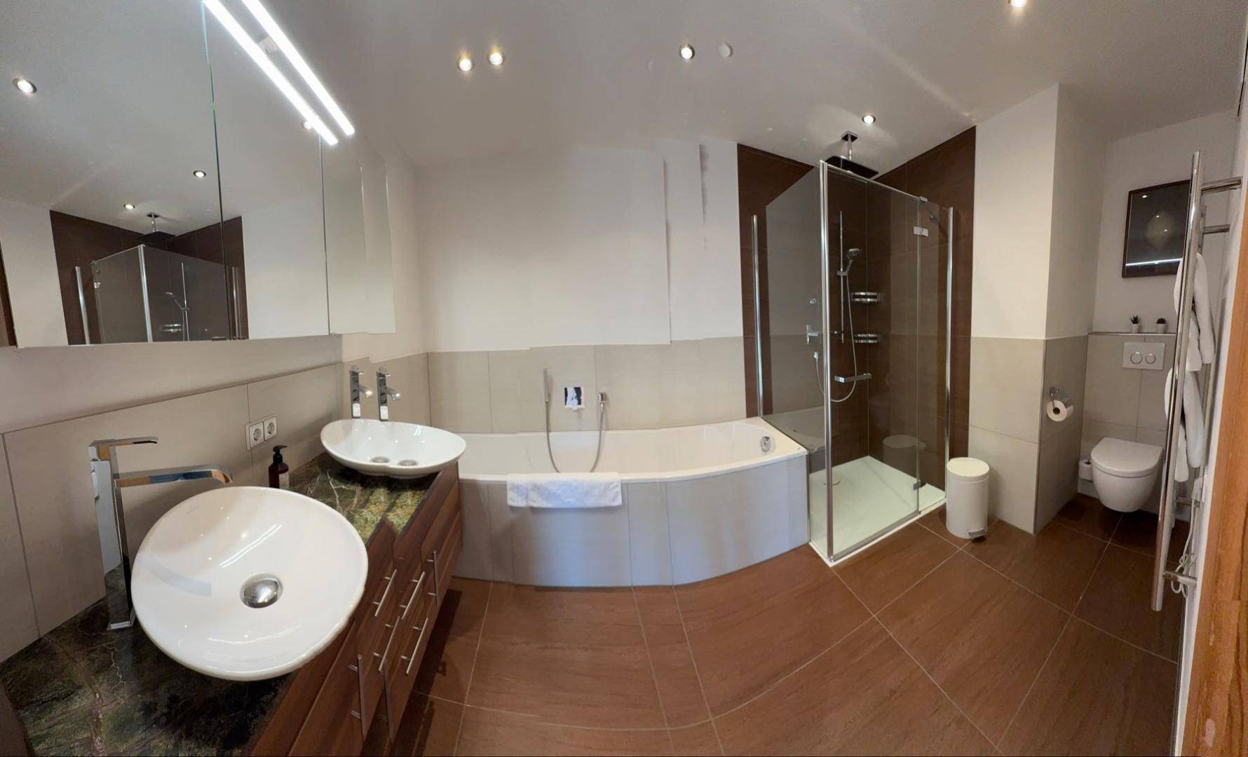 Geräumiges Badezimmer mit Doppelwaschbecken, Badewanne und Duschkabine.