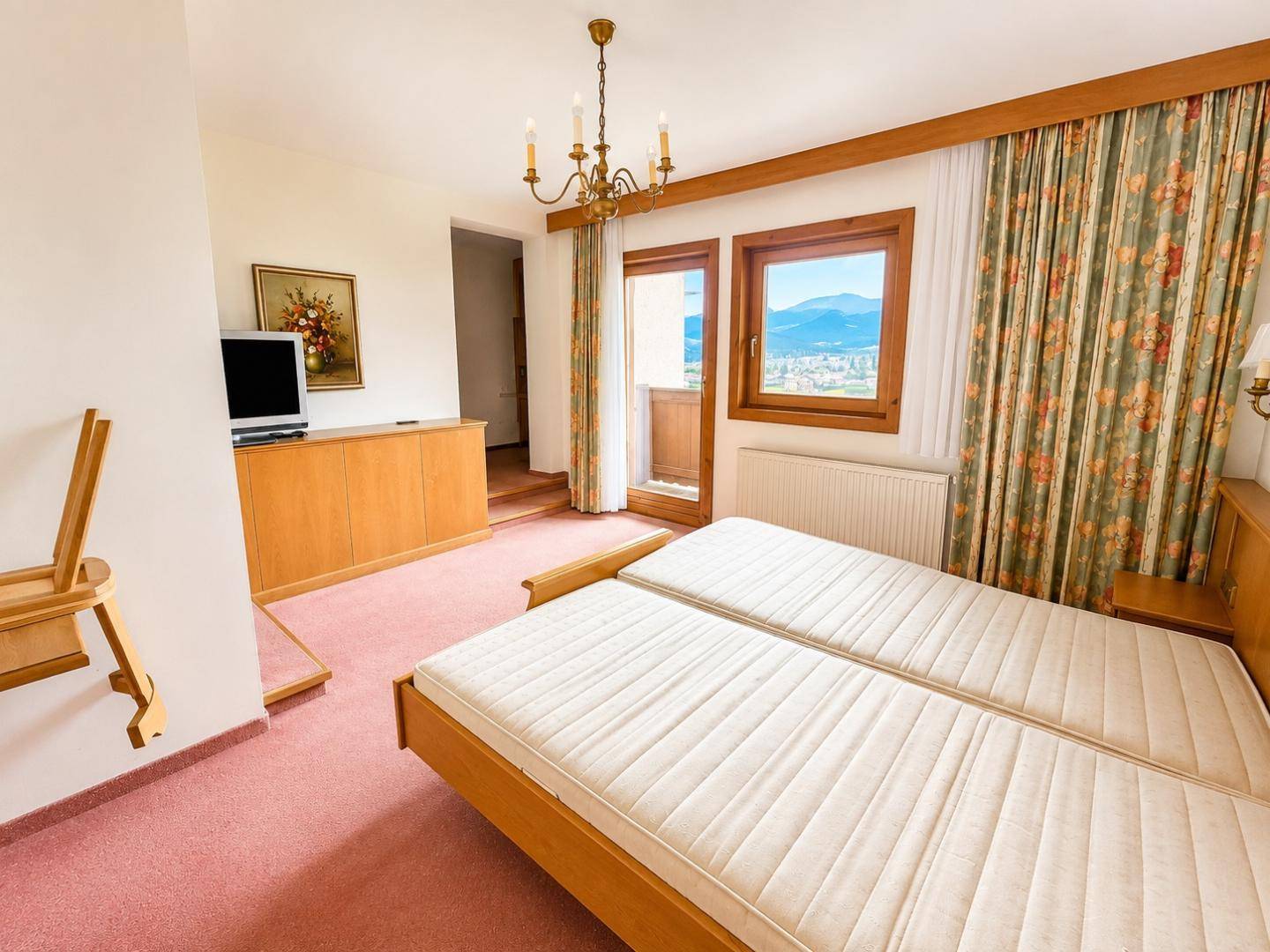 Geräumiges Schlafzimmer mit Doppelbett, Teppichboden und Zugang zu einem Balkon.