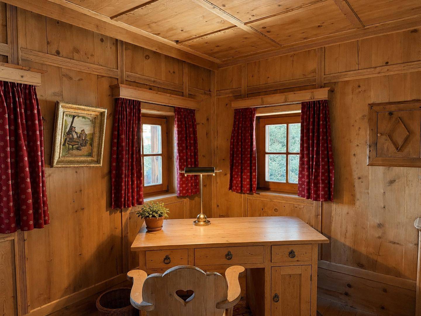 Gemütliches Zimmer mit Holzvertäfelung, Schreibtisch und roten Vorhängen, ideal als Arbeits- oder Schlafzimmer.