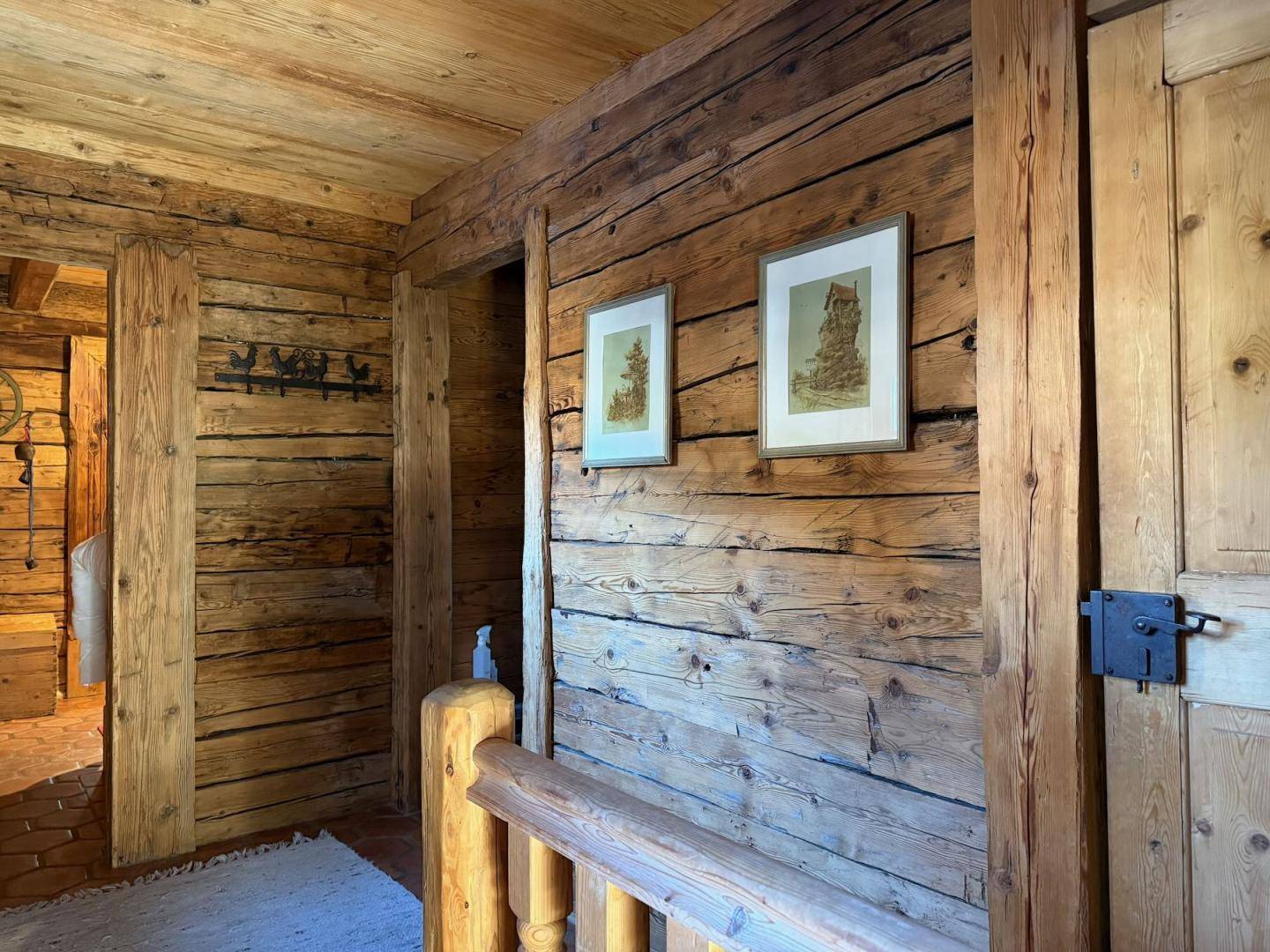 Rustikaler Flur mit Holzwänden und -decken, der den alpinen Charme des Hauses unterstreicht.