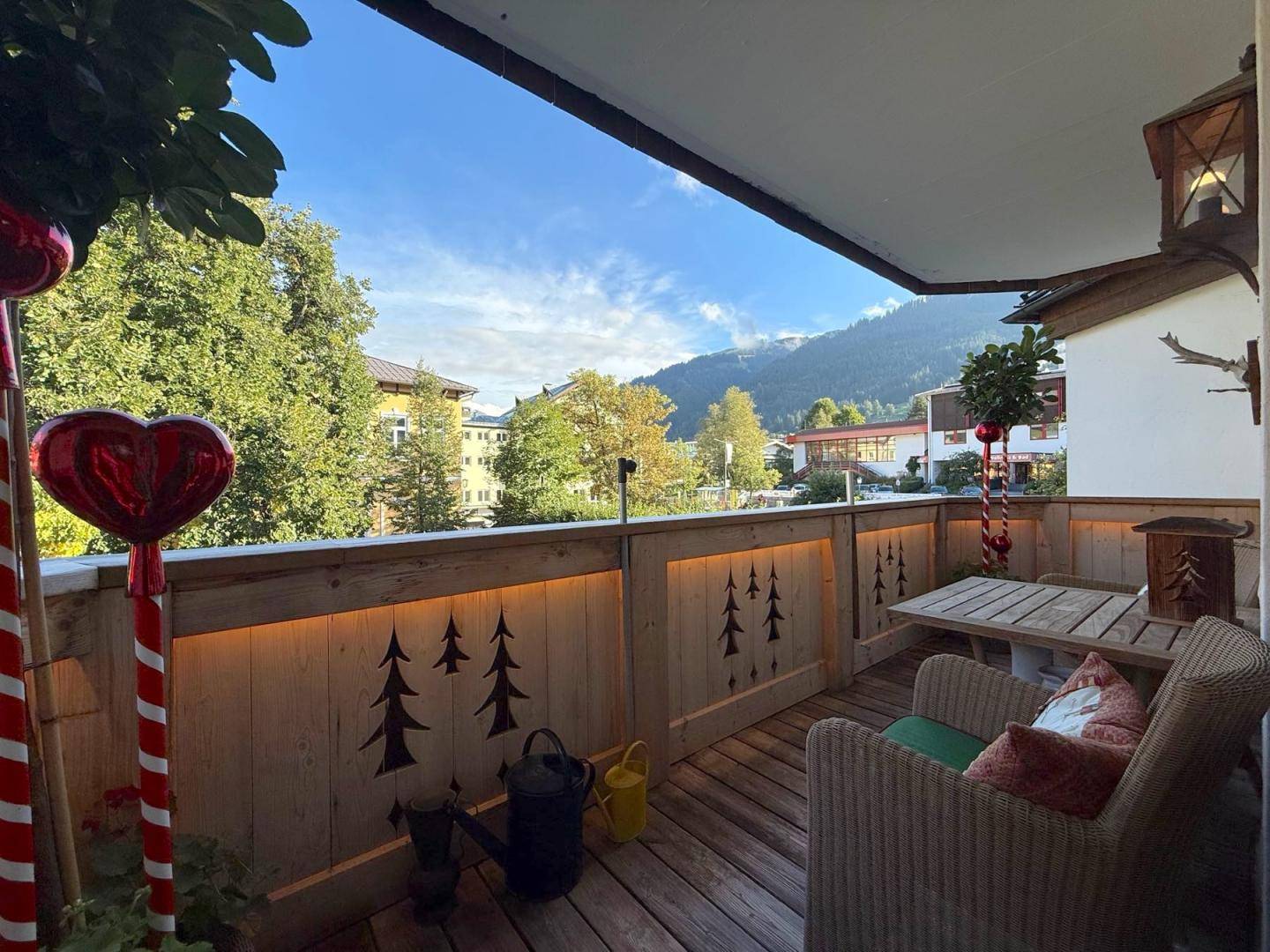 Gemütlicher Balkon mit Sitzgelegenheiten, Holzgeländer und Bergblick in alpiner Umgebung.