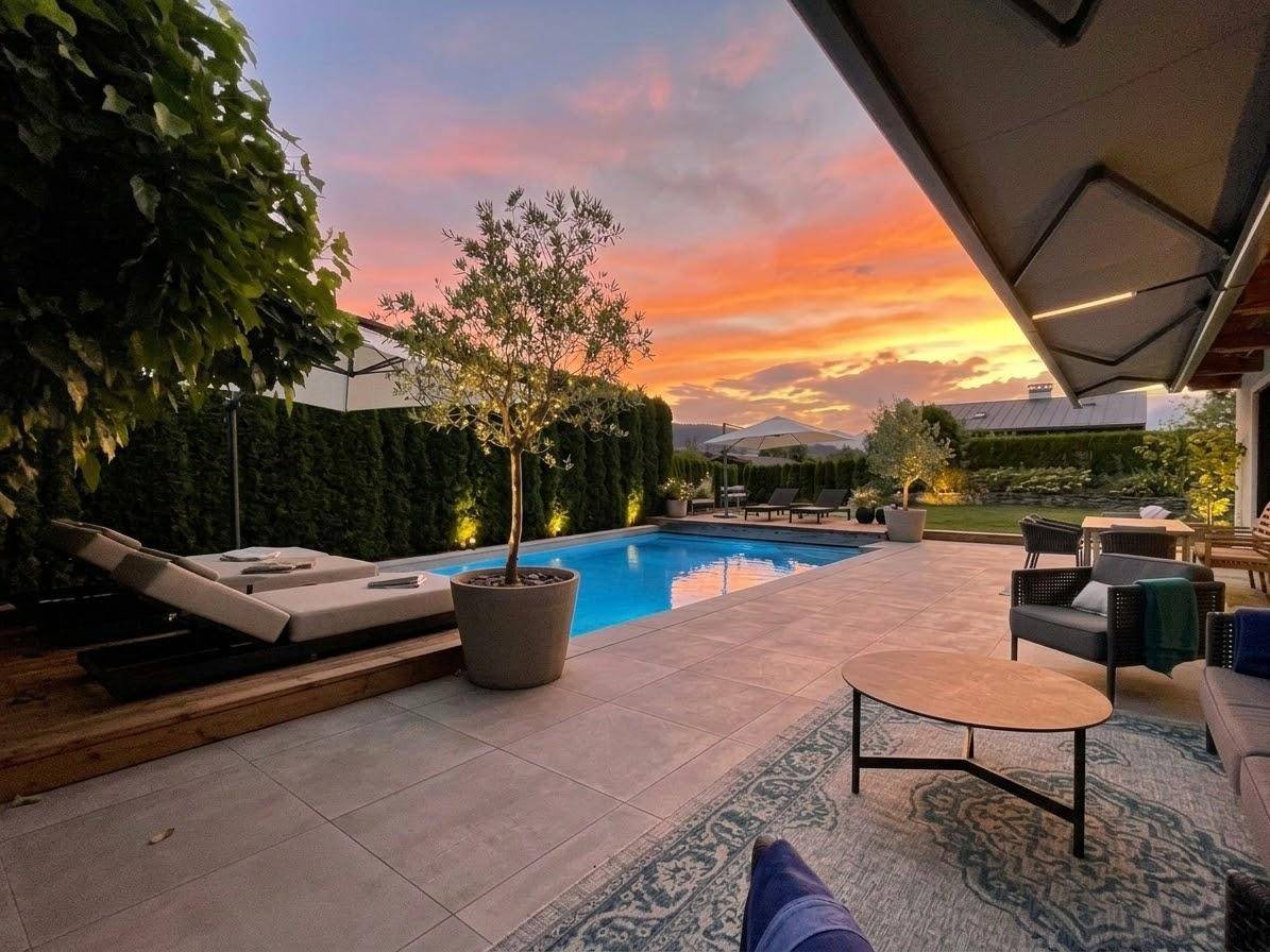 Elegante Terrasse mit Pool und gemütlicher Lounge-Ecke, perfekt für entspannte Stunden im Freien.