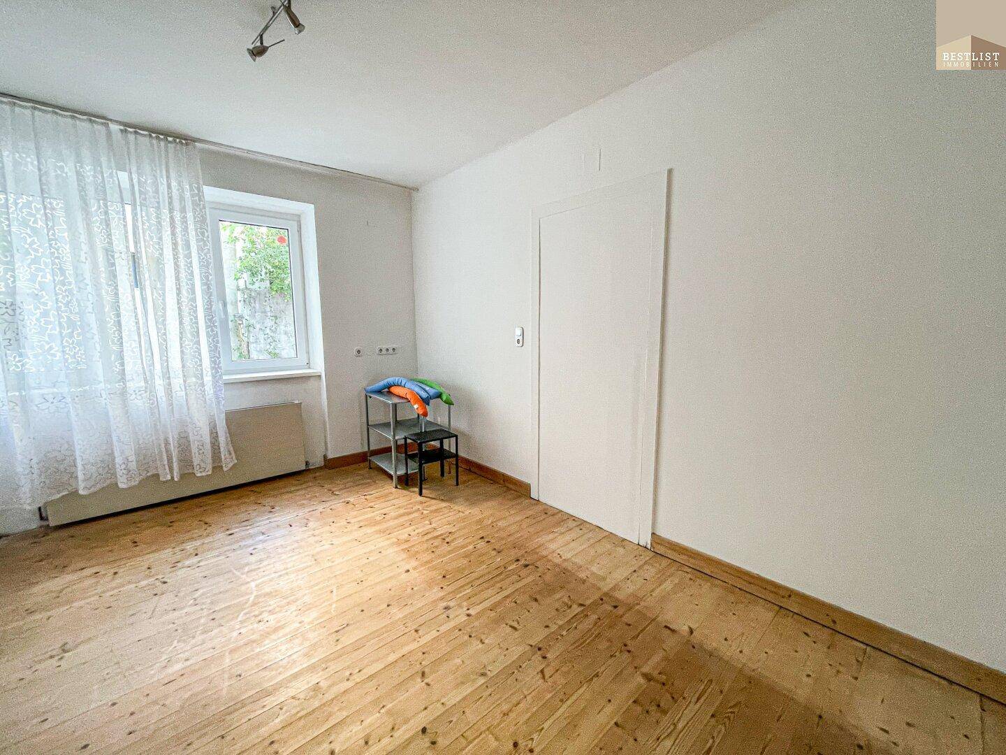 Heller Raum mit Dielenboden und Fenster, bereit zur individuellen Gestaltung und Nutzung.