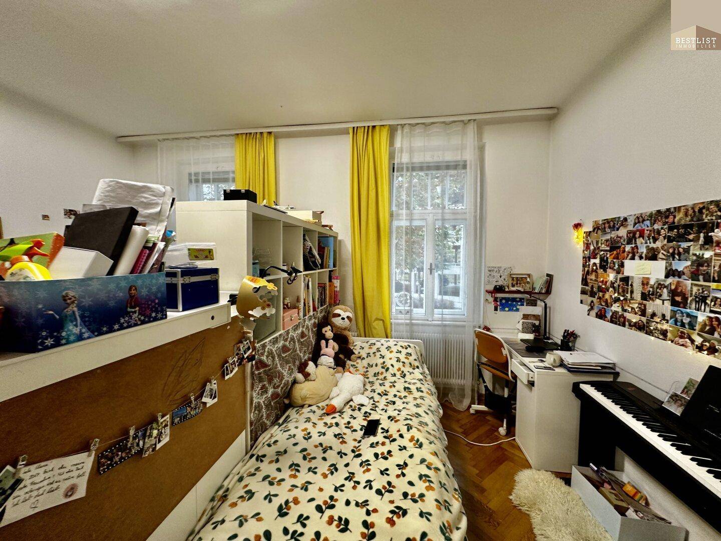 Kinderzimmer mit Einzelbett, Schreibtisch und bunten Dekorationen, hell und freundlich gestaltet.