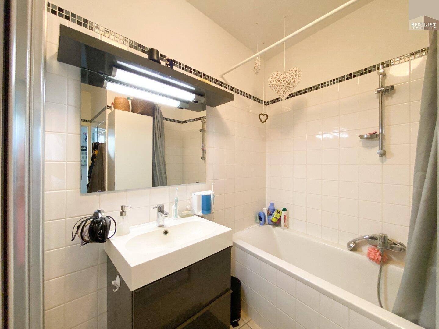 Badezimmer mit Badewanne, Waschbecken und Spiegel.