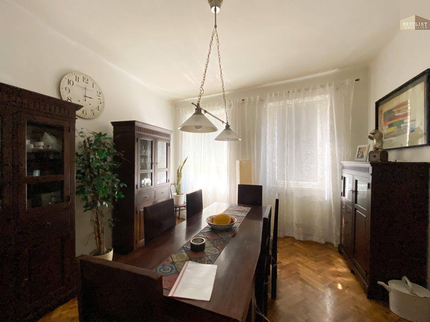 Klassisches Esszimmer mit Holztisch, Stühlen und Parkettboden.