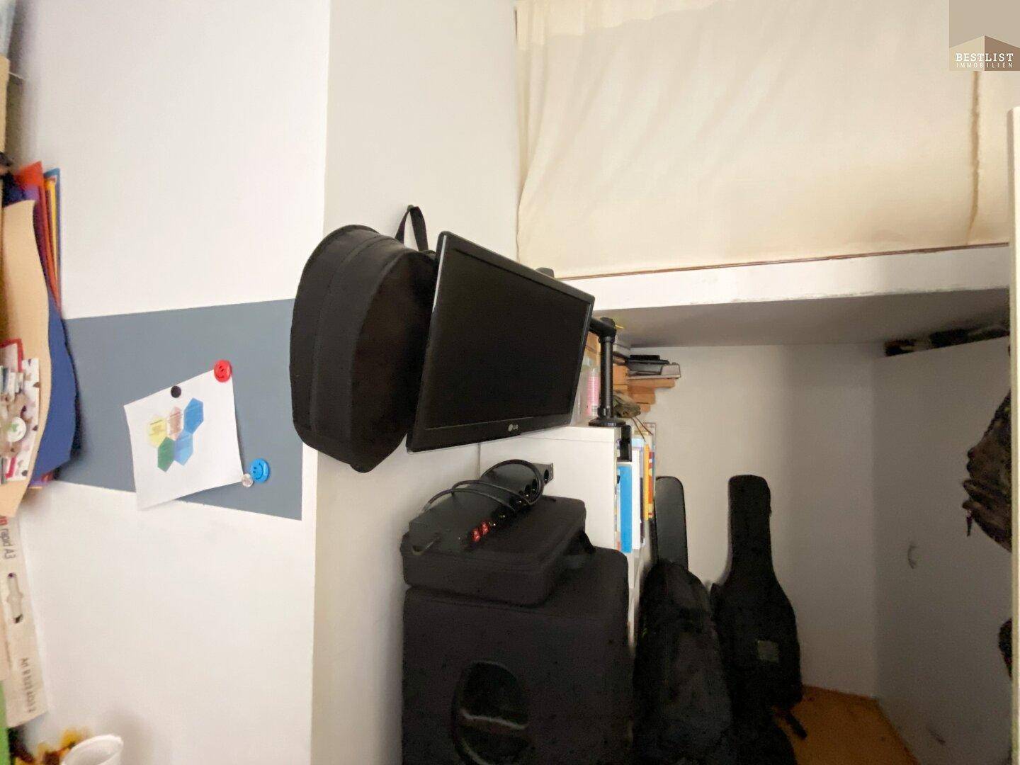 Kleiner Raum mit Hochbett, Fernseher und Stauraum.