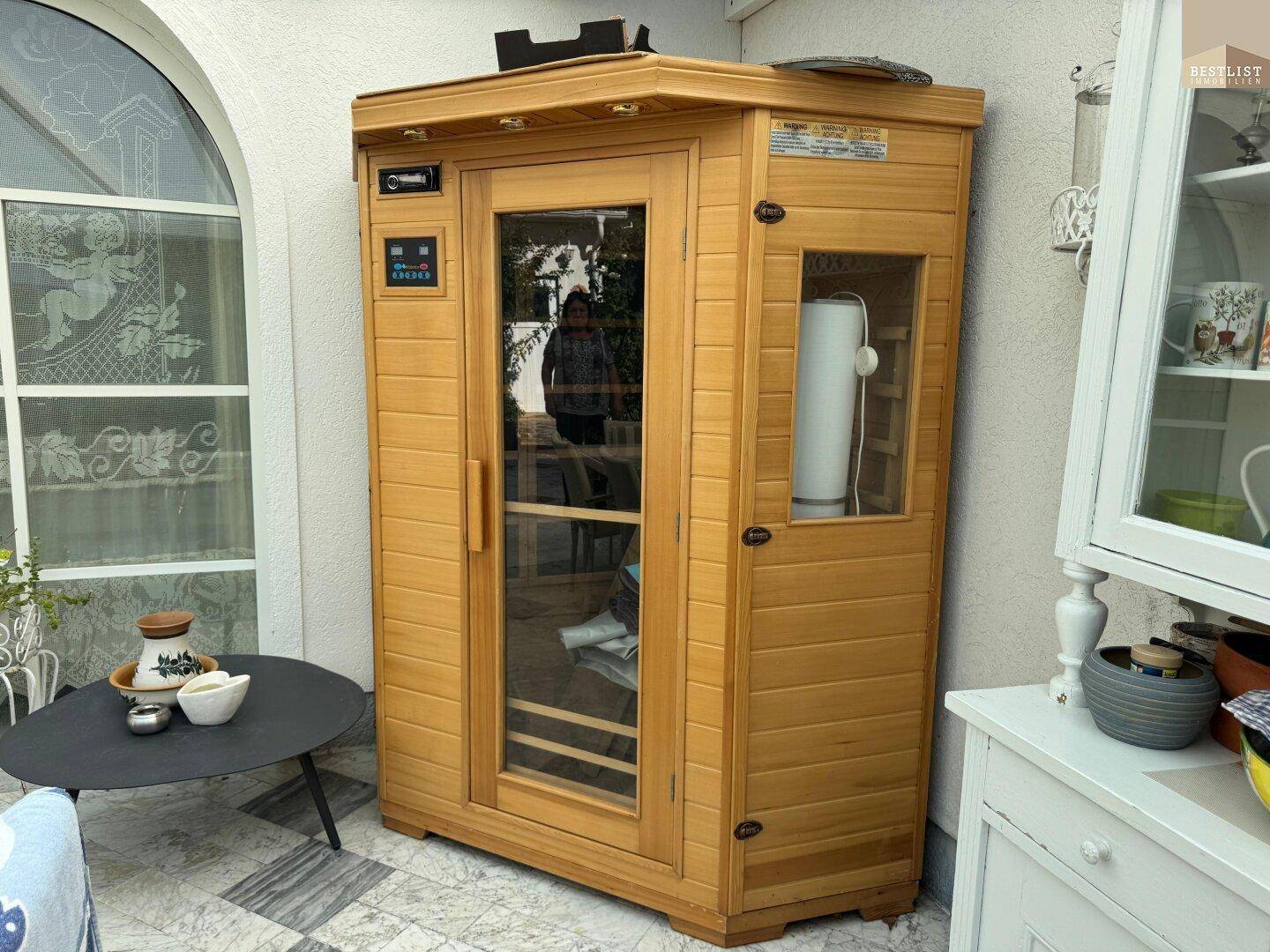 Eine moderne Infrarotsauna steht auf der Terrasse und bietet Entspannung im Freien.