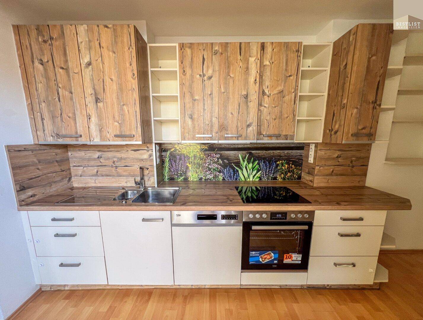 Moderne Küche mit Holzfronten, weißen Unterschränken und integrierten Geräten.