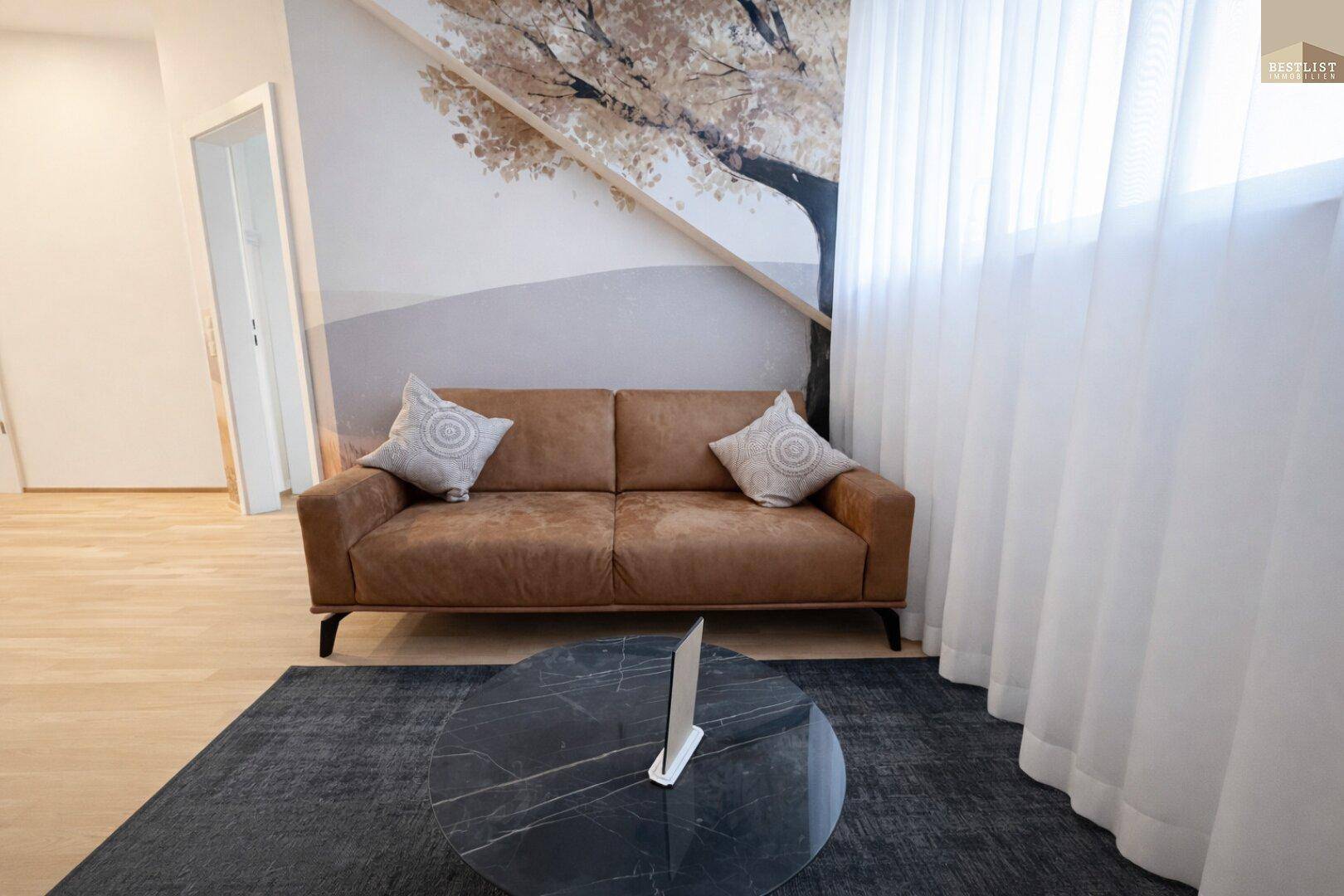 Gemütlicher Wohnbereich mit braunem Sofa, modernem Couchtisch und dekorativer Wandgestaltung.