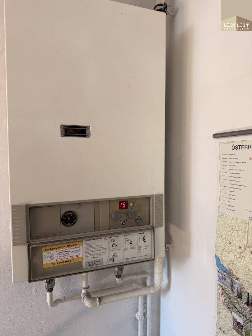 Gastherme an einer weißen Wand, die für Heizung und Warmwasser sorgt.