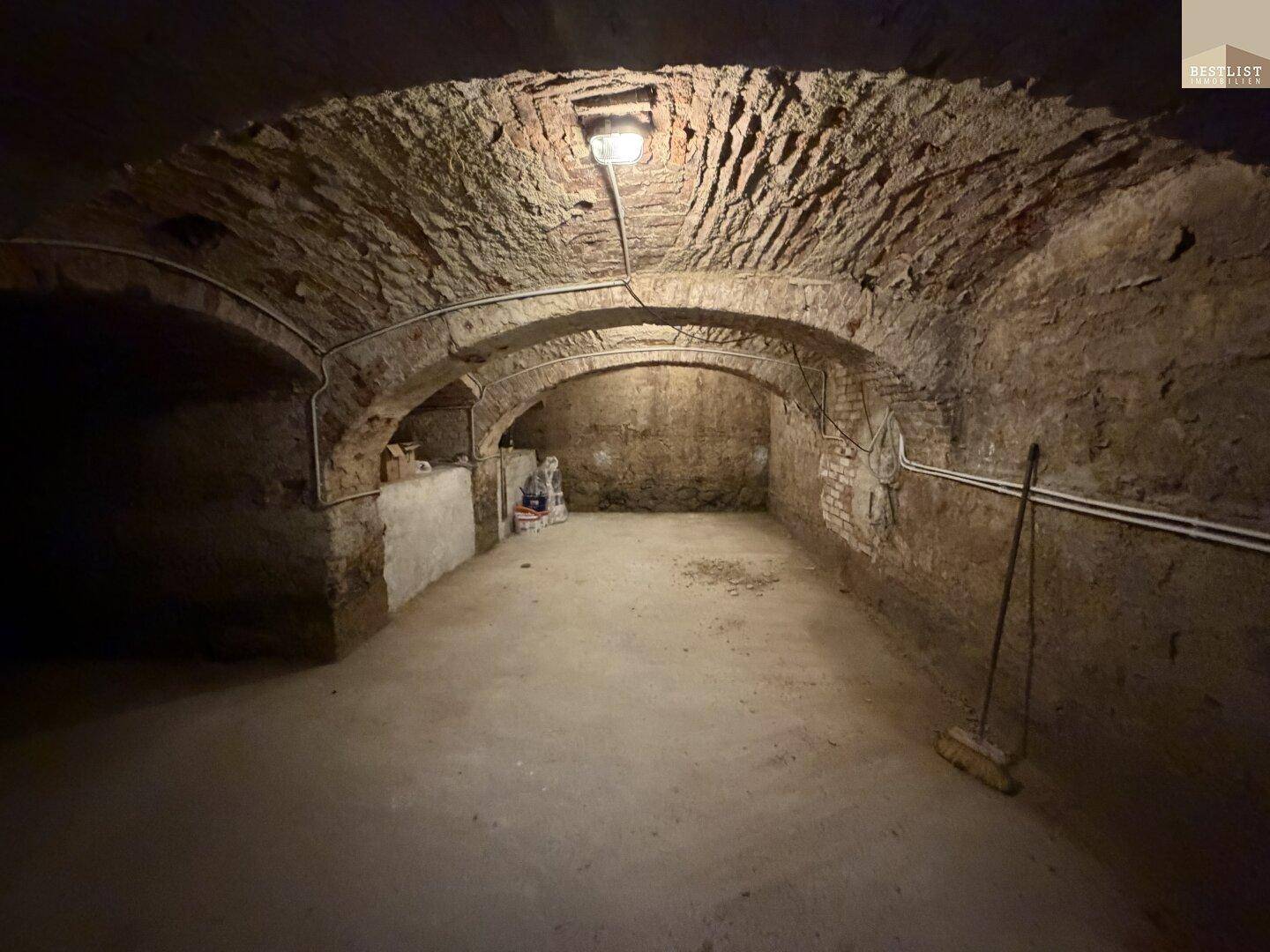 Historischer Kellerraum mit freiliegenden Ziegelgewölben und robustem Betonboden.