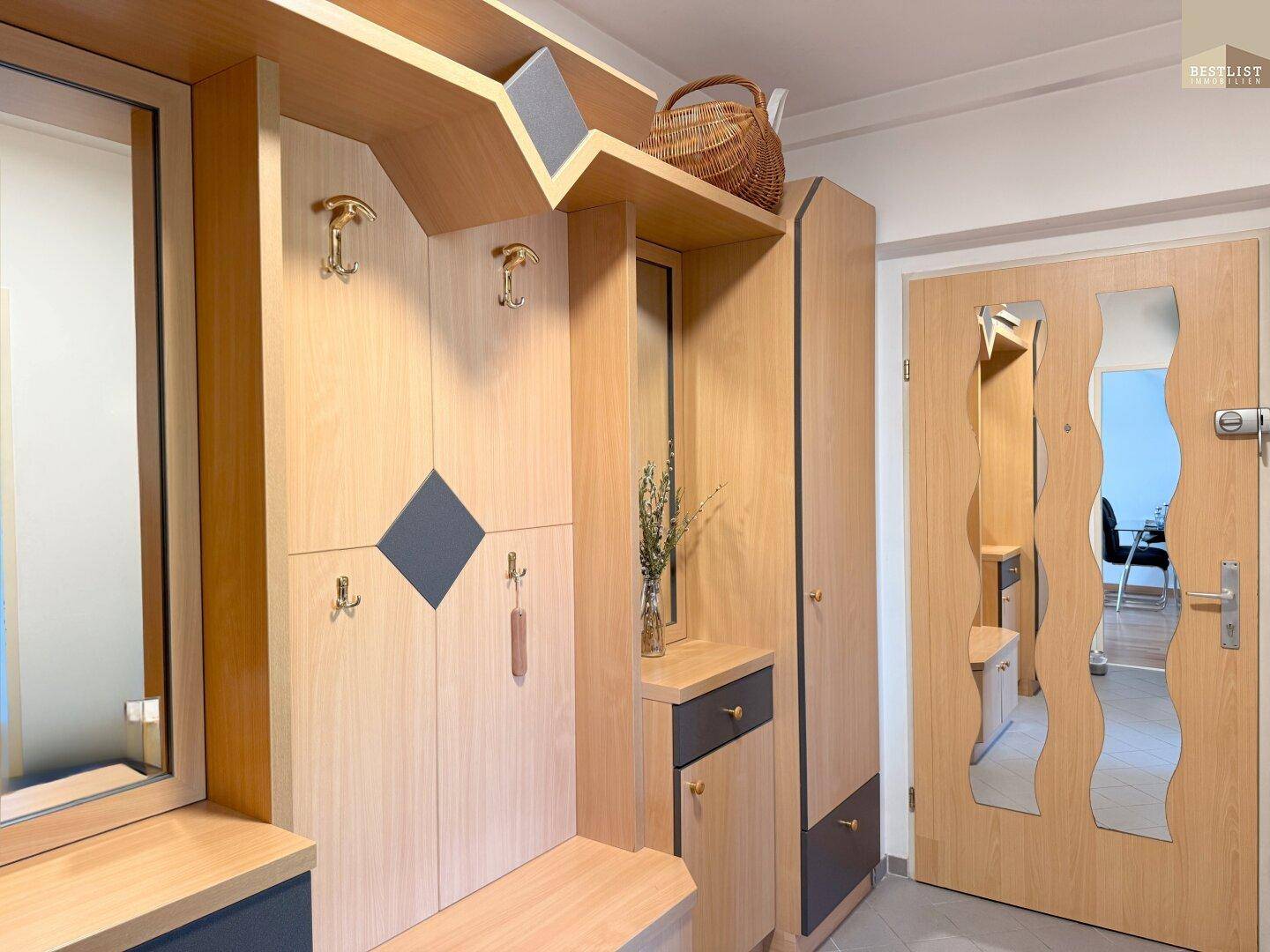 Eingangsbereich mit praktischer Garderobe aus Holz und Spiegeln für den täglichen Gebrauch.