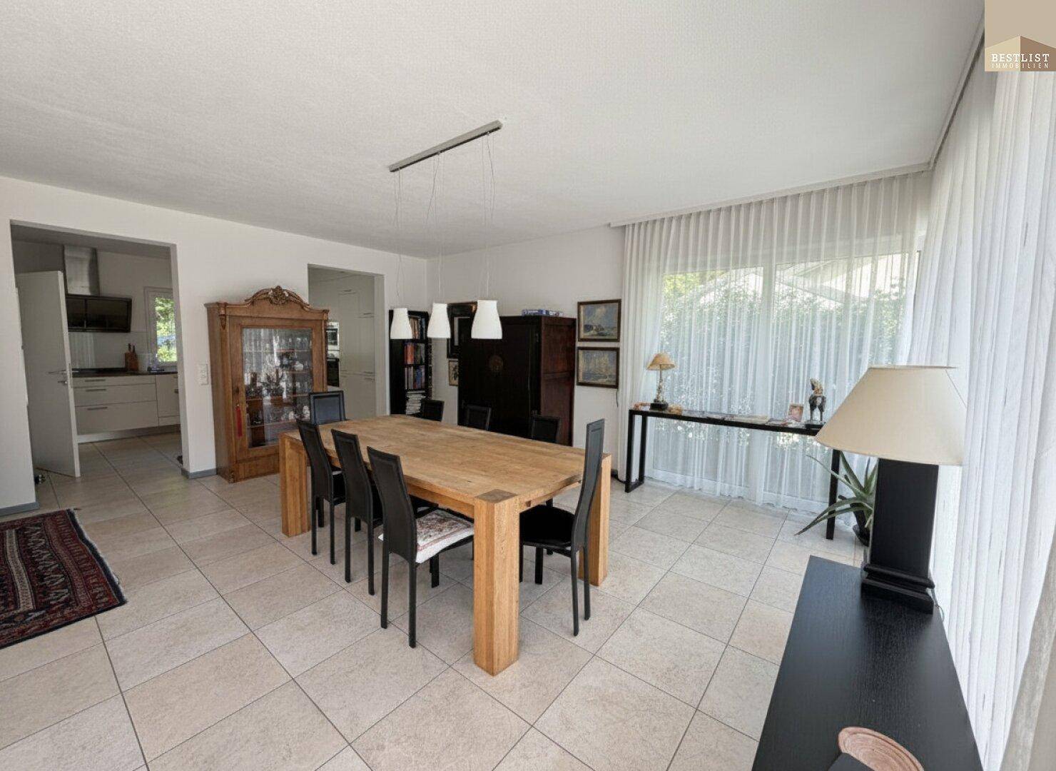 Geräumiger Essbereich mit Holztisch und Blick auf den Garten, ideal für Familienessen.