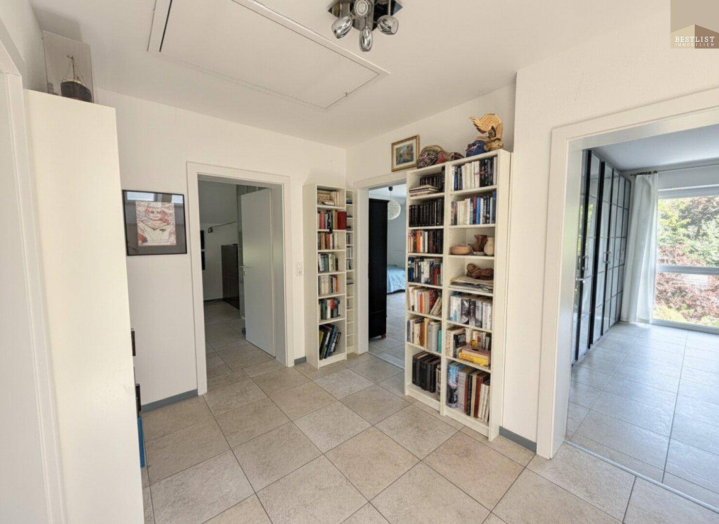 Heller Flur mit Bücherregalen und Zugang zu den oberen Schlafzimmern.
