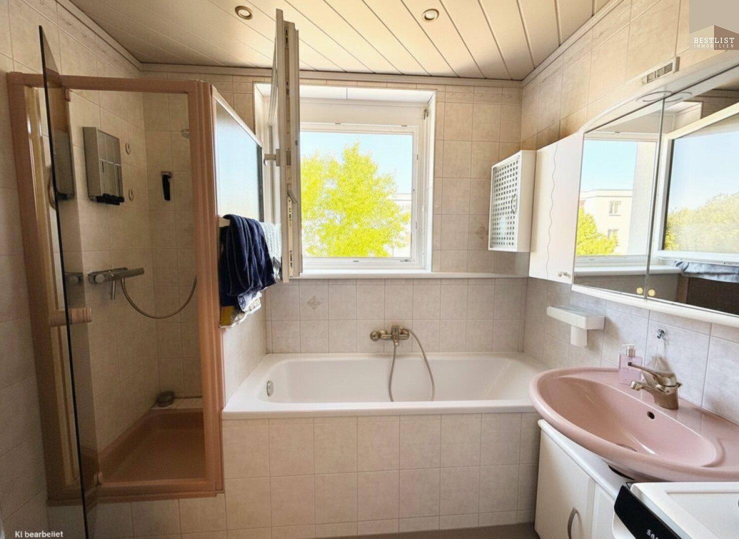 Badezimmer mit Badewanne, Duschkabine, Waschbecken und Fenster für Tageslicht.