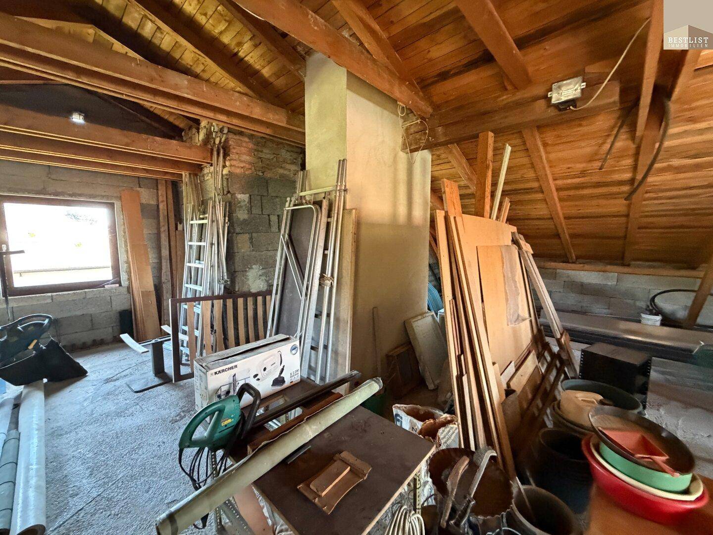 Unausgebauter Dachboden mit Holzbalken und Lagerfläche für verschiedene Materialien und Werkzeuge.