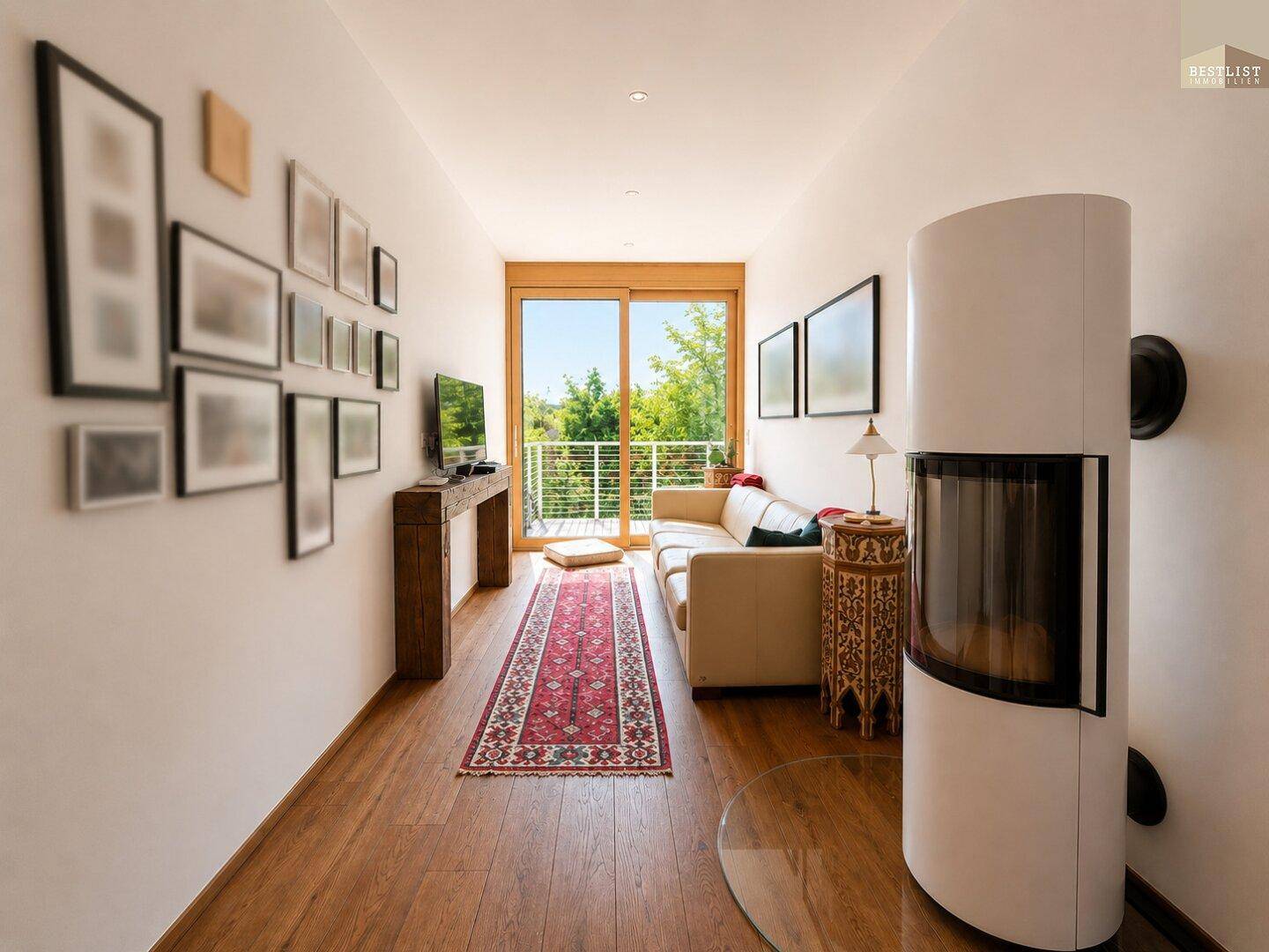 Gemütliches Wohnzimmer mit modernem Kaminofen, Holzboden und Balkonzugang.