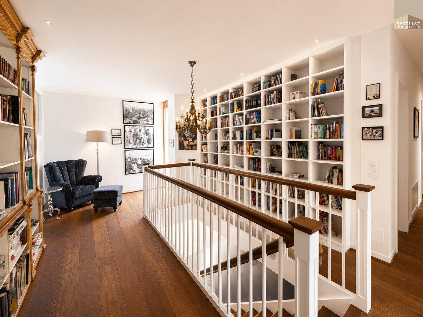 Offener Bibliotheksbereich im Obergeschoss mit vielen Bücherregalen und Leseecke.