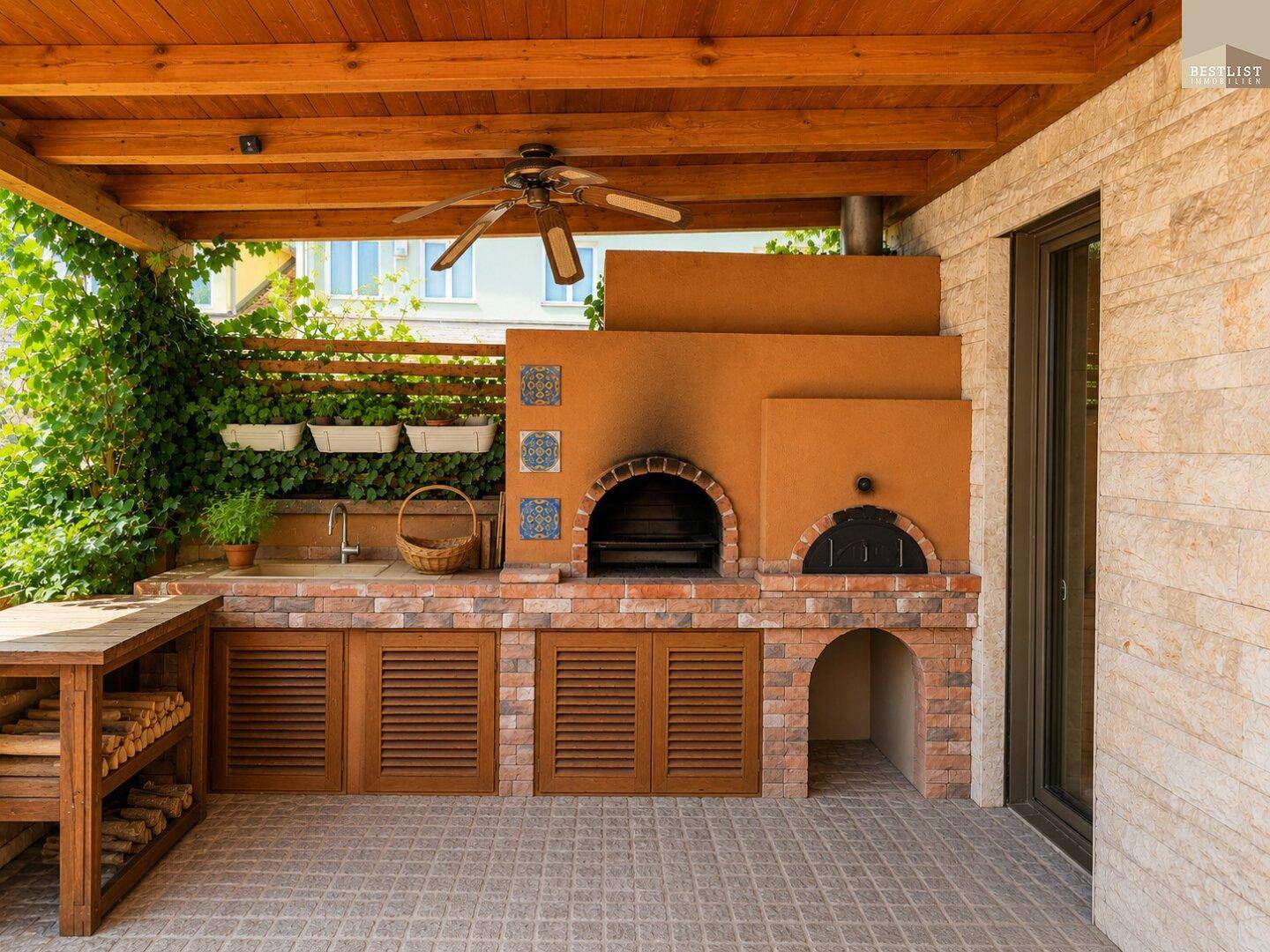 Überdachte Terrasse mit Außenküche, Pizzaofen und Grillbereich für gesellige Abende.