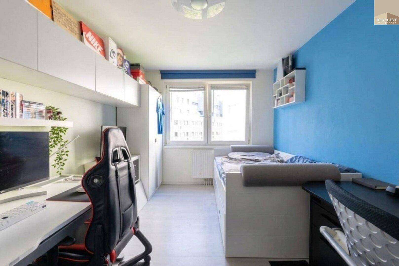 Jugendzimmer mit Einzelbett, Schreibtisch und einer blauen Akzentwand.