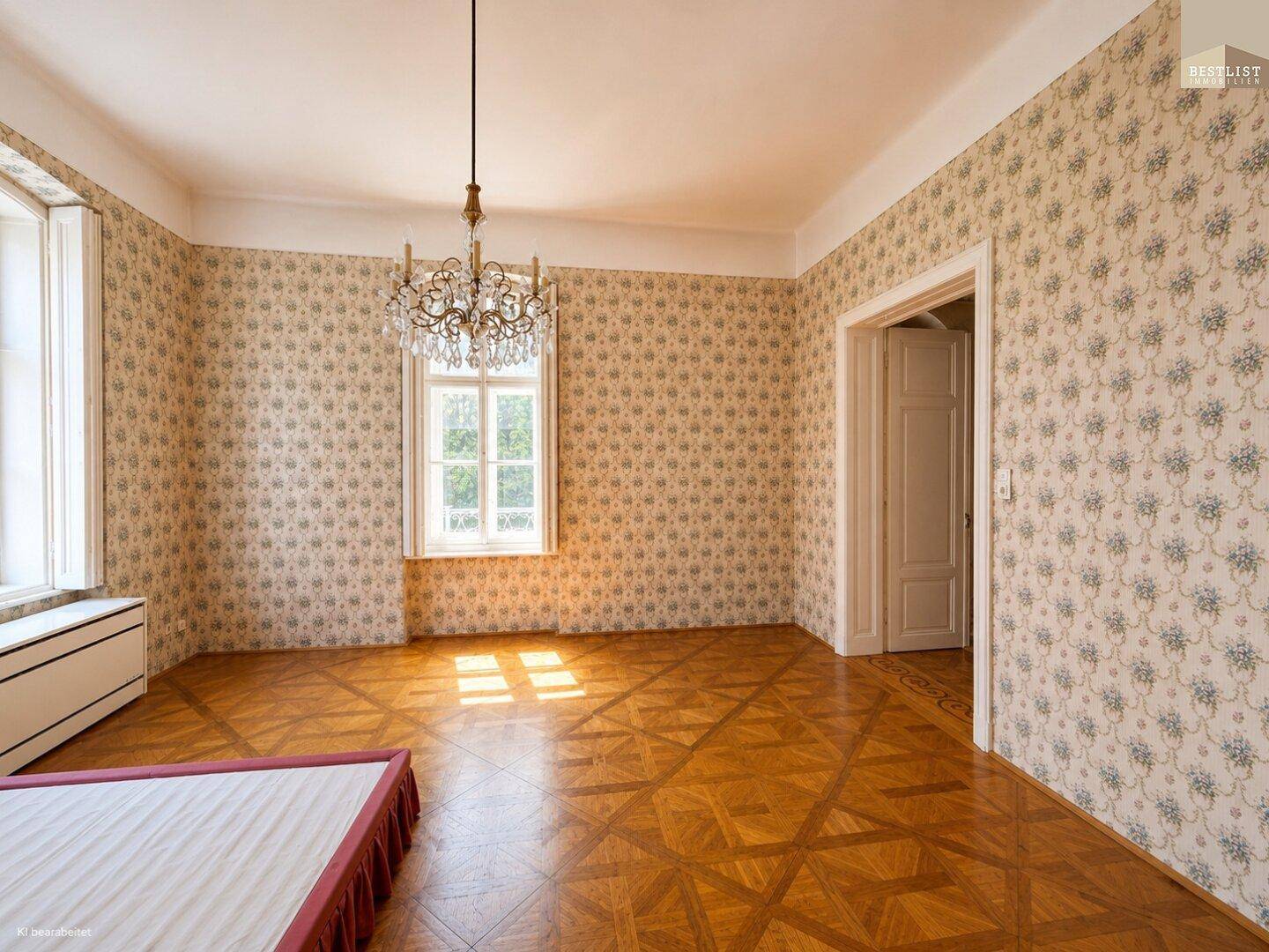 Schlafzimmer mit gemusterten Tapeten, elegantem Parkettboden und einem opulenten Kronleuchter.
