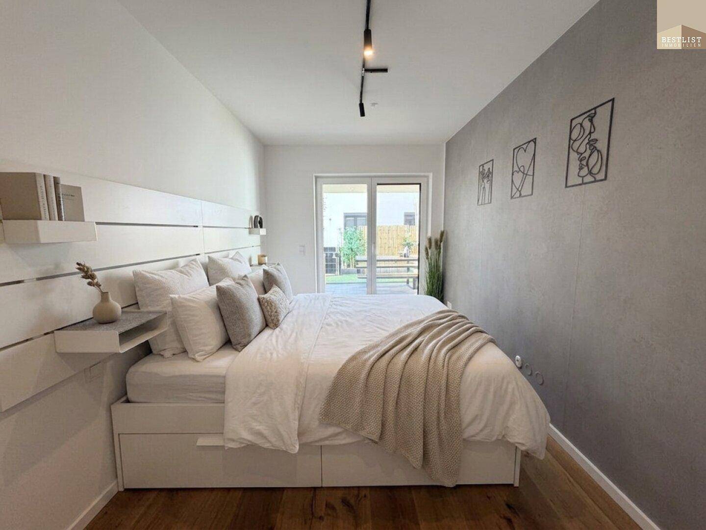 Modernes Schlafzimmer mit großem Bett, Holzboden und Zugang zum Garten.