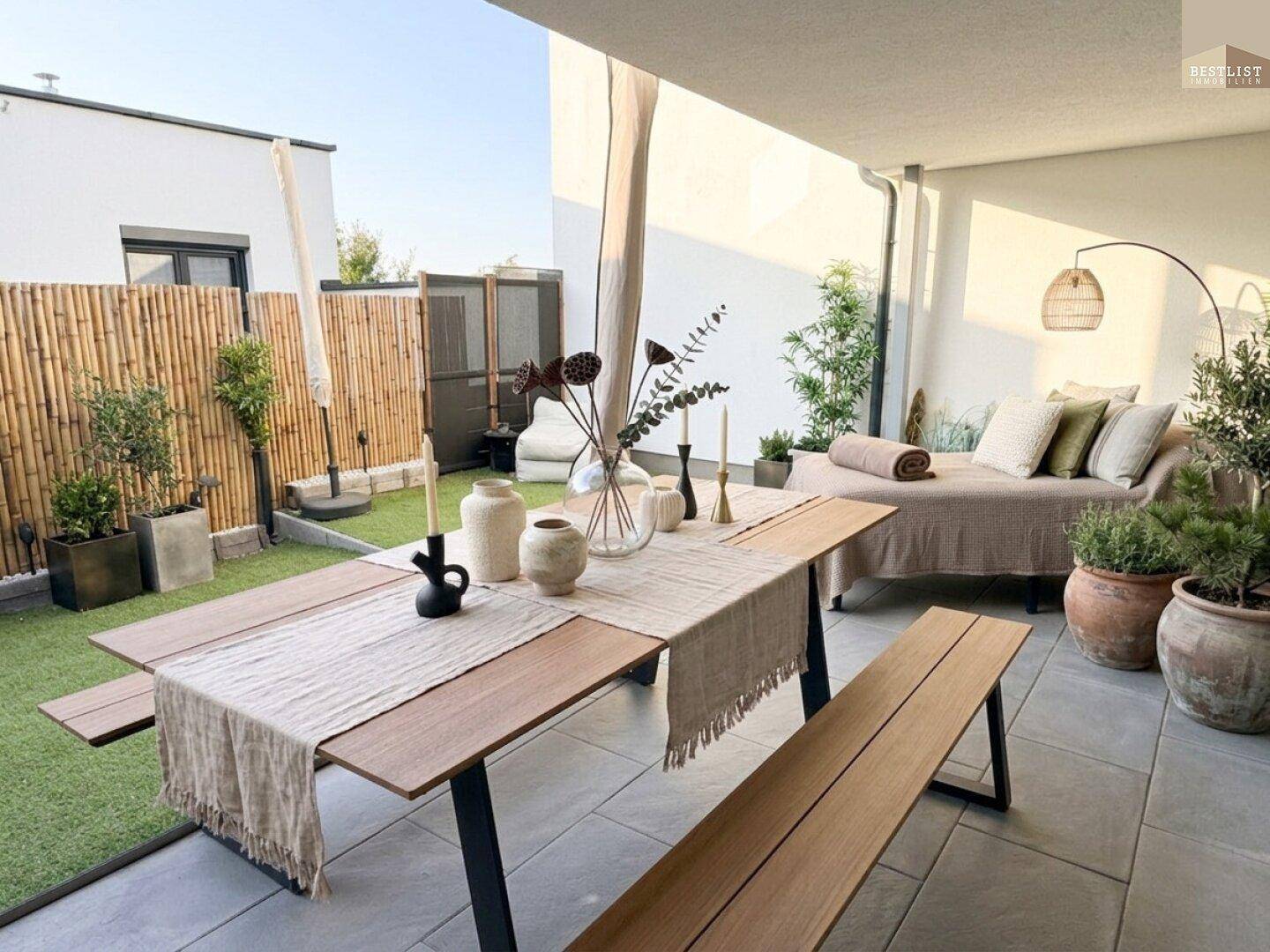 Gemütlicher Gartenbereich mit Esstisch, Sitzgelegenheiten und Kunstrasen.