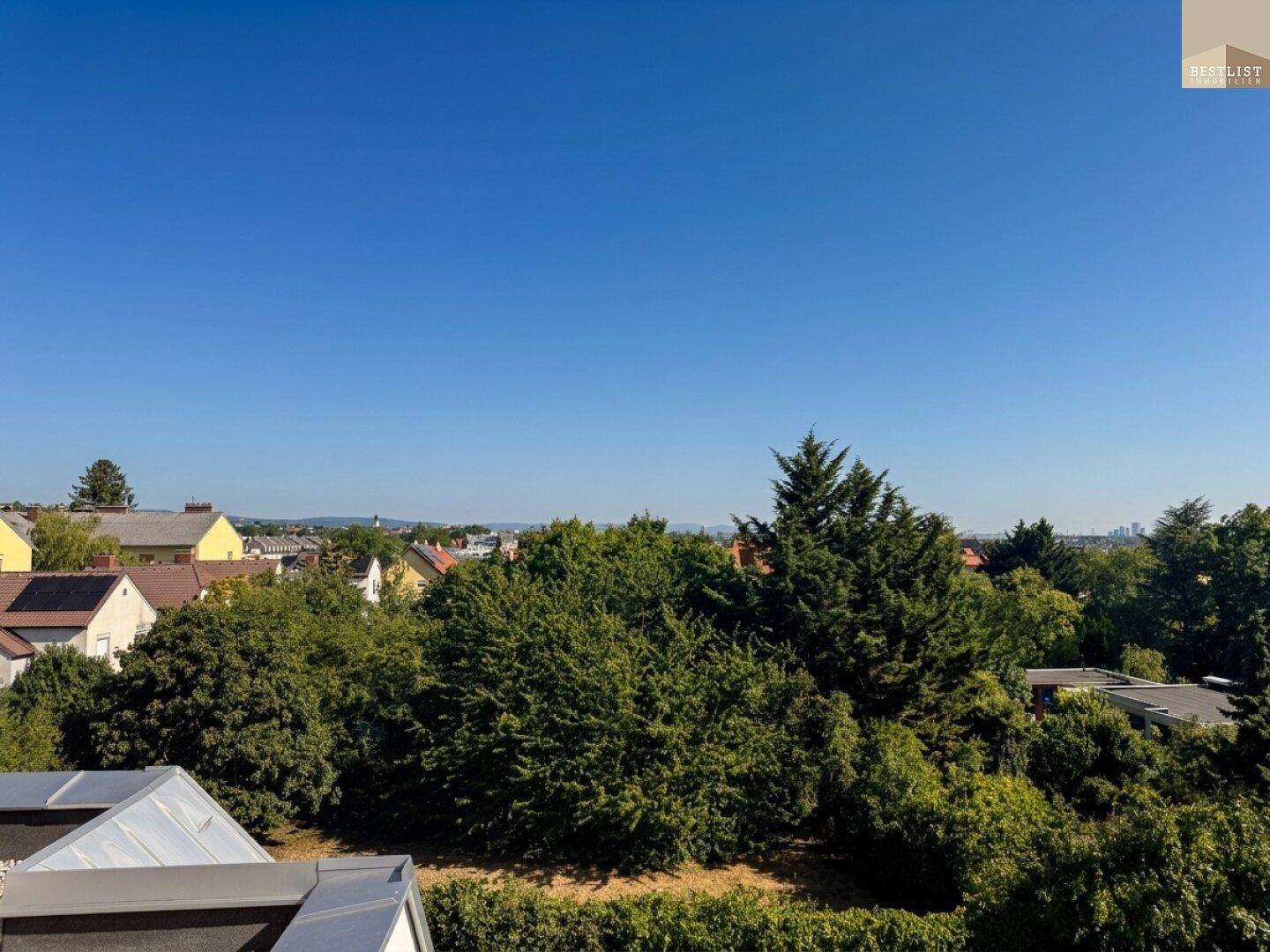 Panoramablick über die grüne Landschaft und die Dächer der umliegenden Wohngegend.