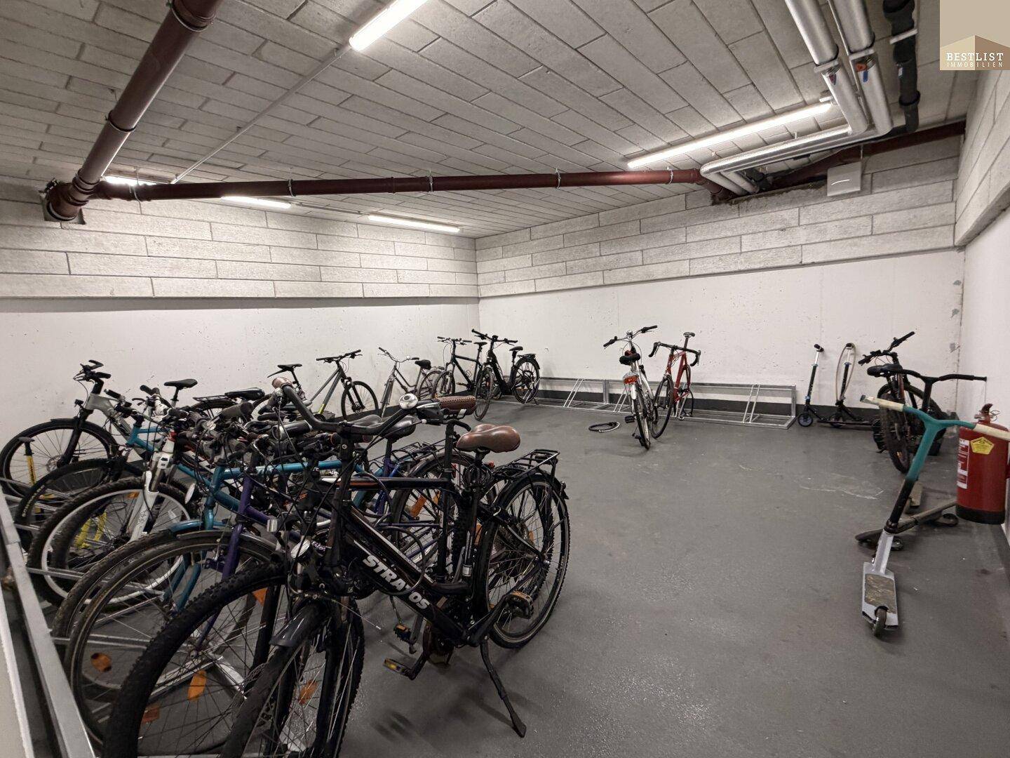 Geräumiger Fahrradraum in der Tiefgarage mit vielen Stellplätzen und Beleuchtung.