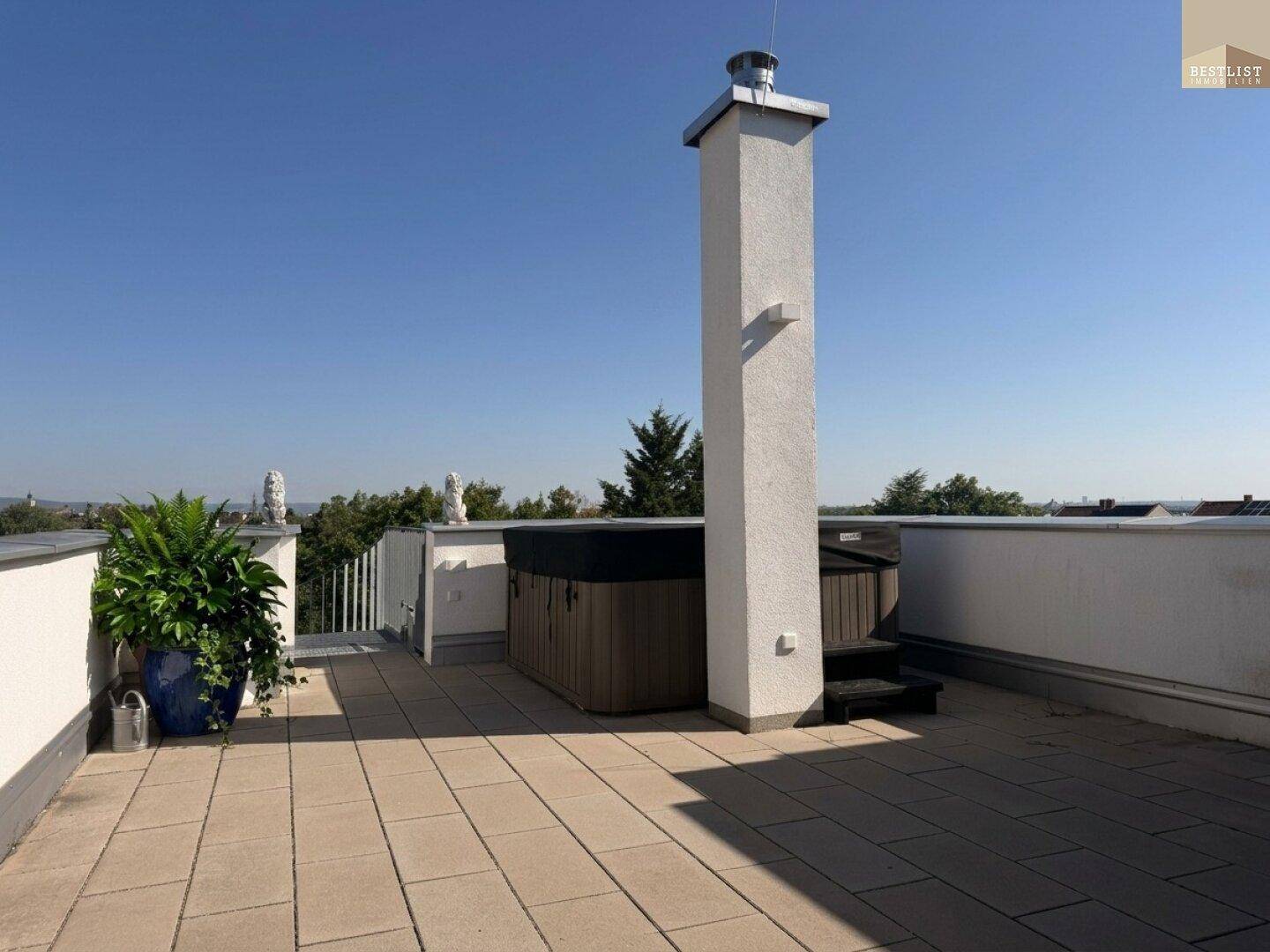 Geräumige Dachterrasse mit Whirlpool, Kamin und weitem Blick über die Landschaft.