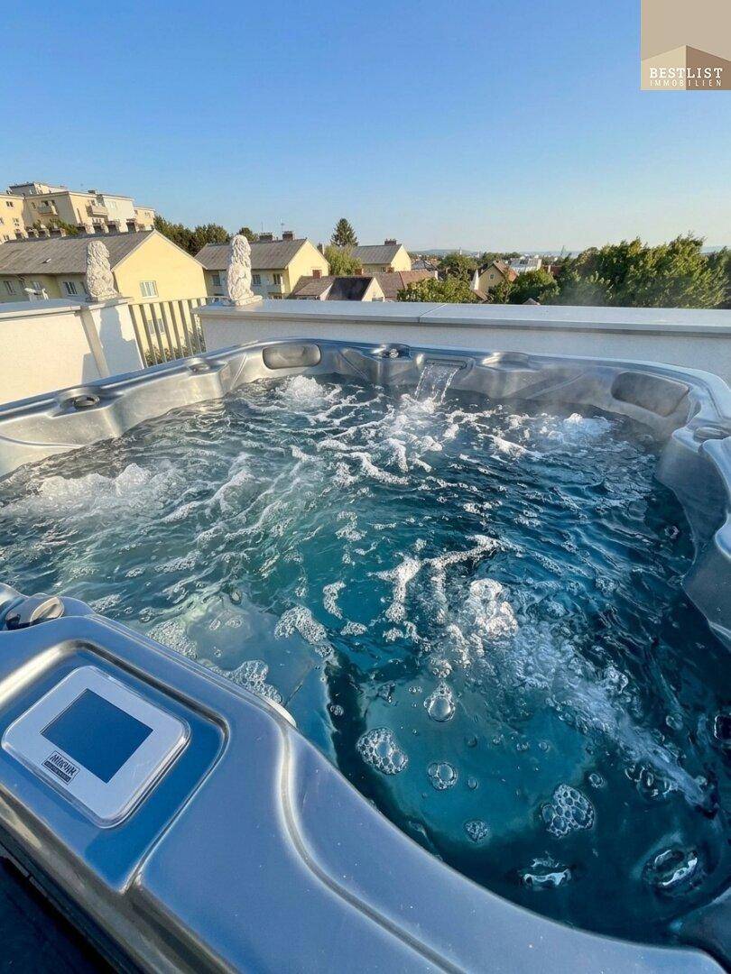 Sprudelnder Whirlpool auf der Dachterrasse mit weitem Blick über die umliegende Wohngegend.