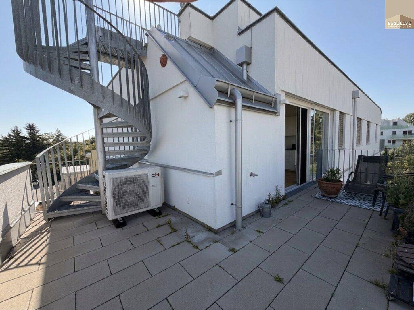 Große Dachterrasse mit Wendeltreppe, Klimaanlage und weitem Blick ins Grüne.