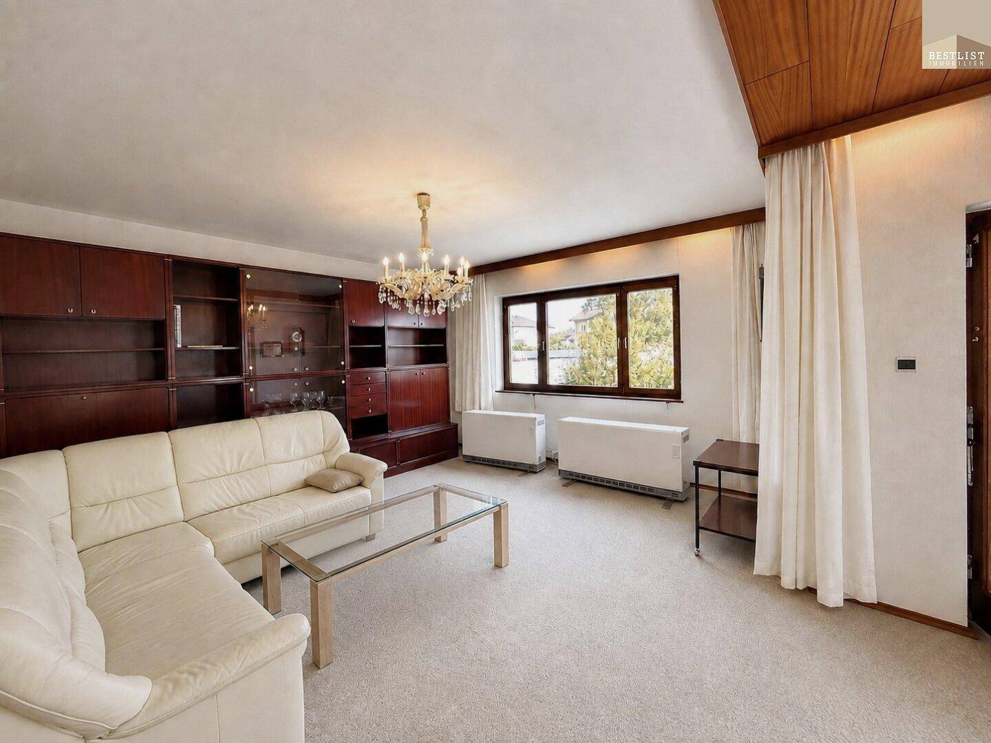 Gemütliches Wohnzimmer mit Teppichboden, Ledersofa und Einbauschränken.