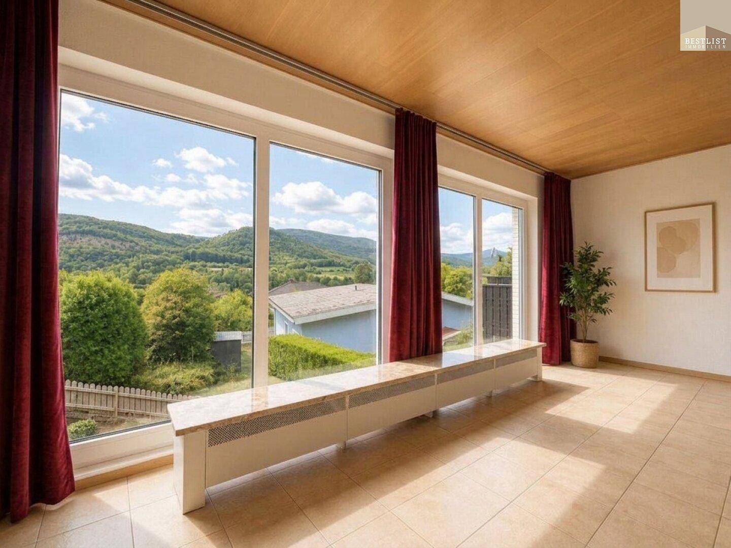 Helles Zimmer mit großen Fenstern, die einen weiten Blick auf die grüne Landschaft bieten.