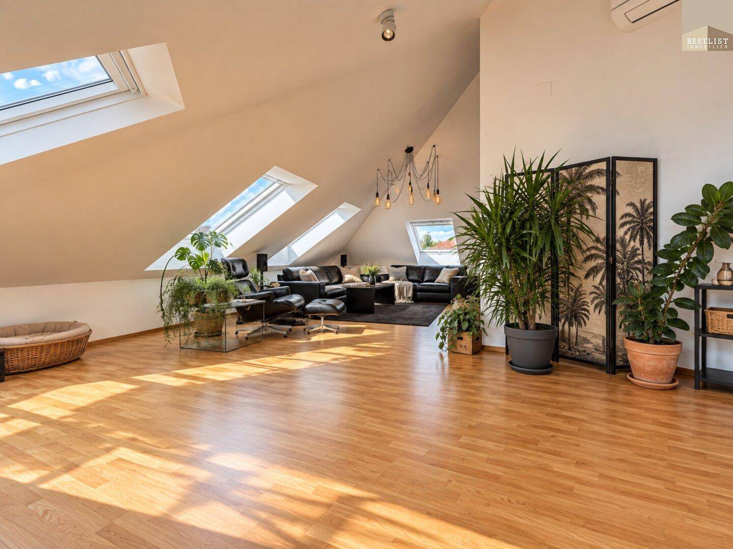 Geräumiges Wohnzimmer im Dachgeschoss mit hohen Decken, viel Tageslicht und modernen Möbeln.