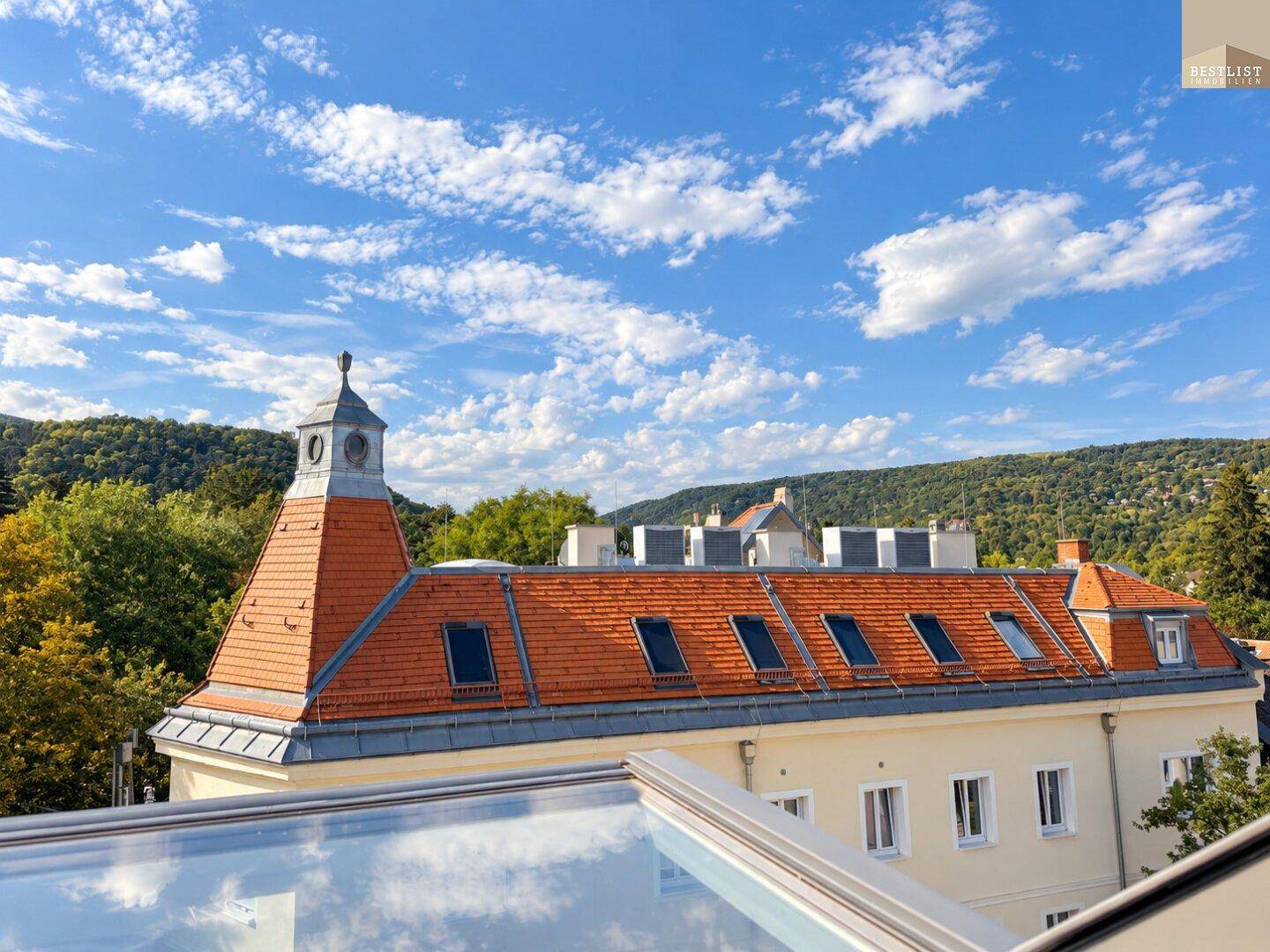 Historisches Gebäude mit markantem Dach und Blick auf die umliegende Stadtlandschaft.