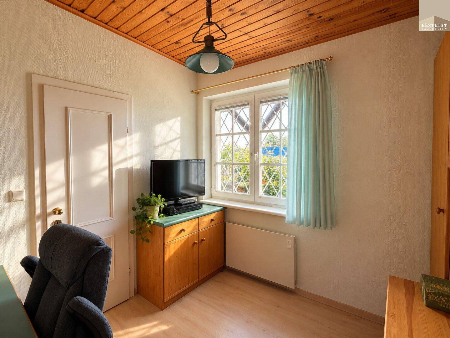Kleines Zimmer mit Holzdecke, Fenster und Blick ins Grüne, ideal als Büro oder Gästezimmer.