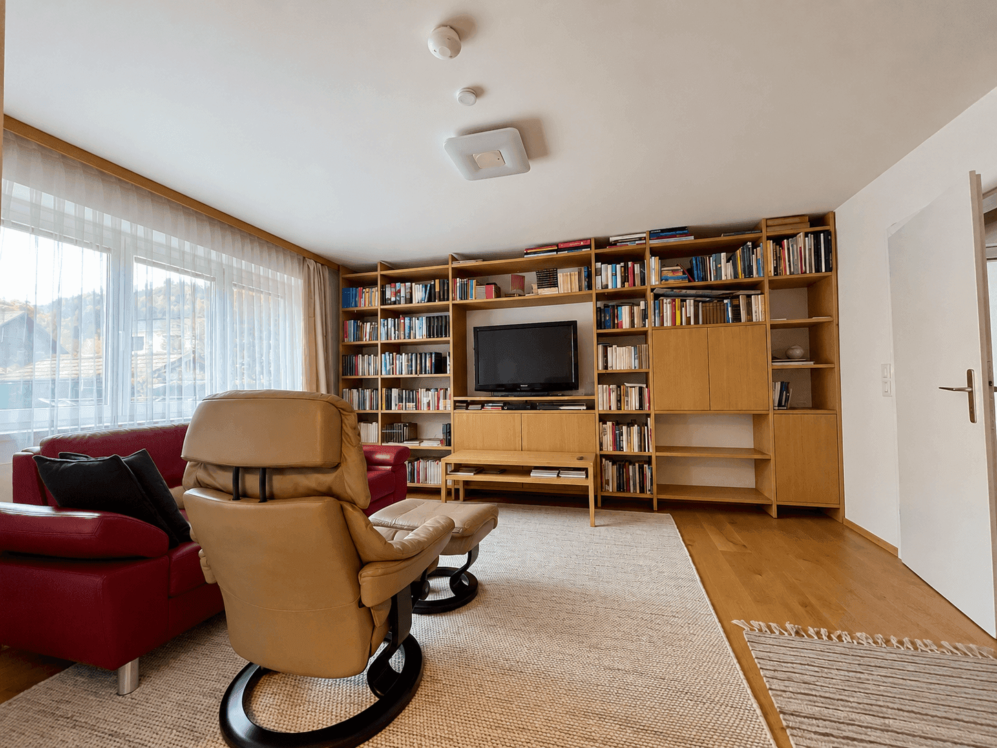 Aufgeräumtes Wohnzimmer mit Bücherwand