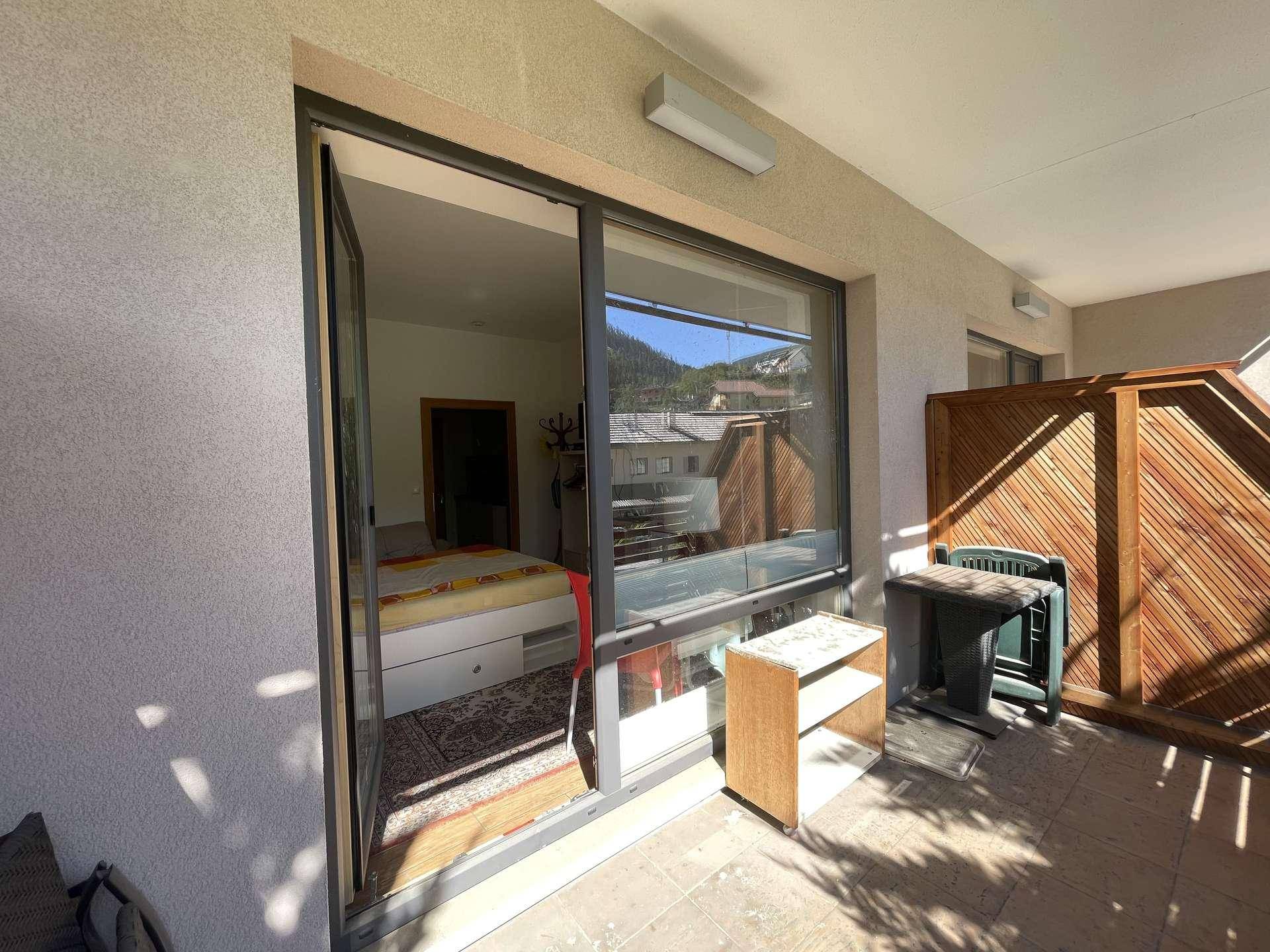 Geräumiger Balkon mit Zugang zum Schlafzimmer und Blick auf die Berglandschaft.