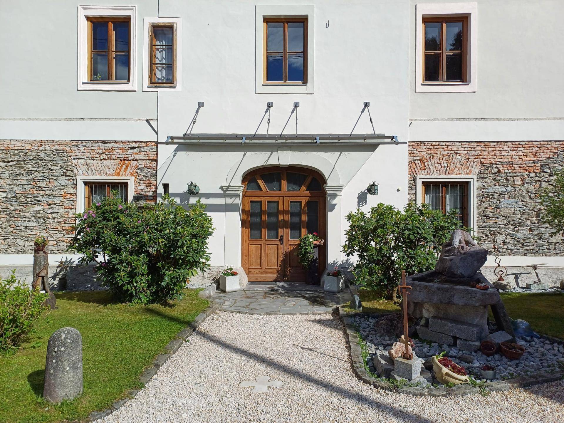 Eingangsbereich des historischen Gebäudes mit Holztür und Steindetails.