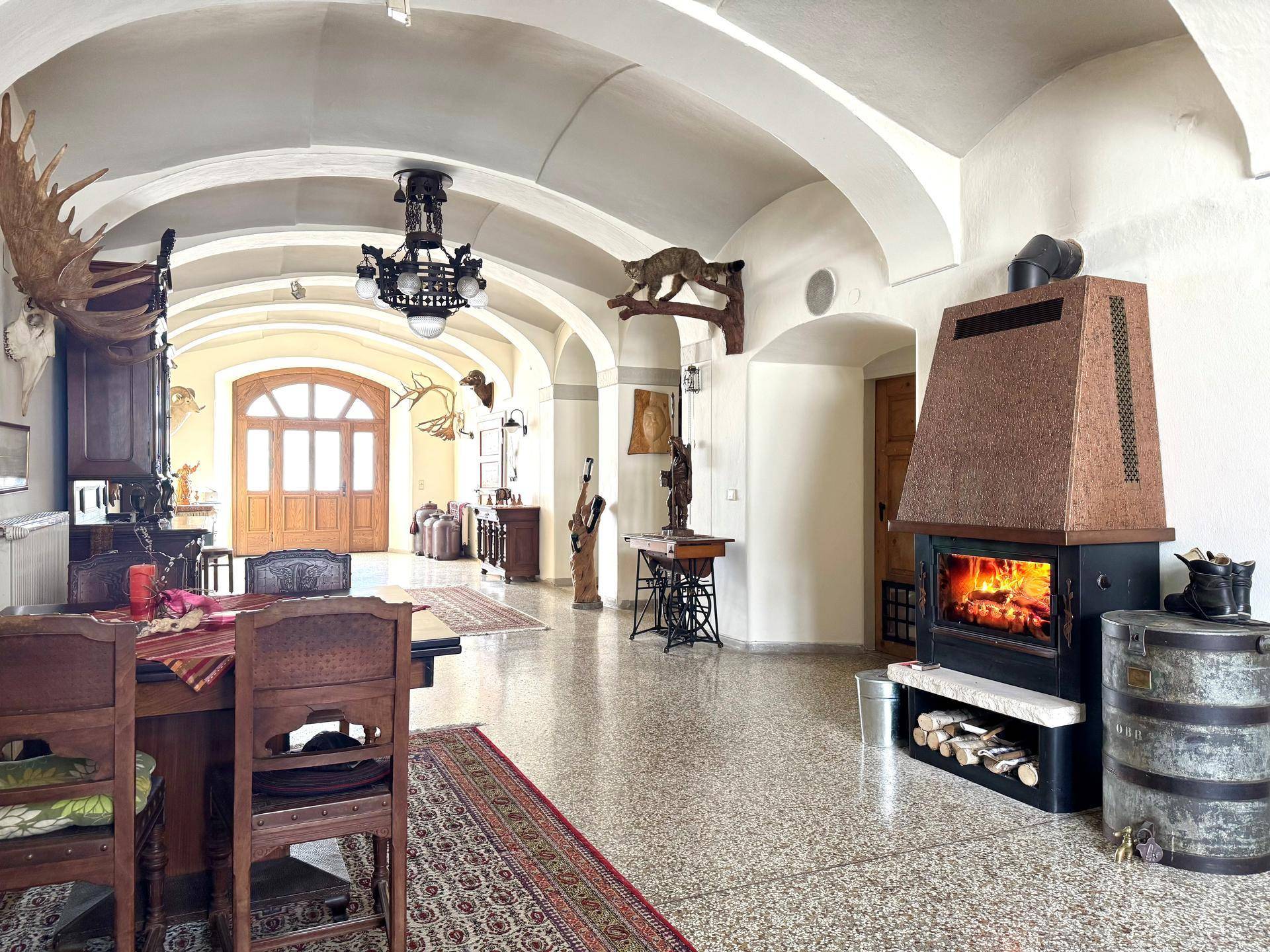 Großer Empfangsbereich mit Gewölbedecken, Kamin und traditionellen Jagdtrophäen.