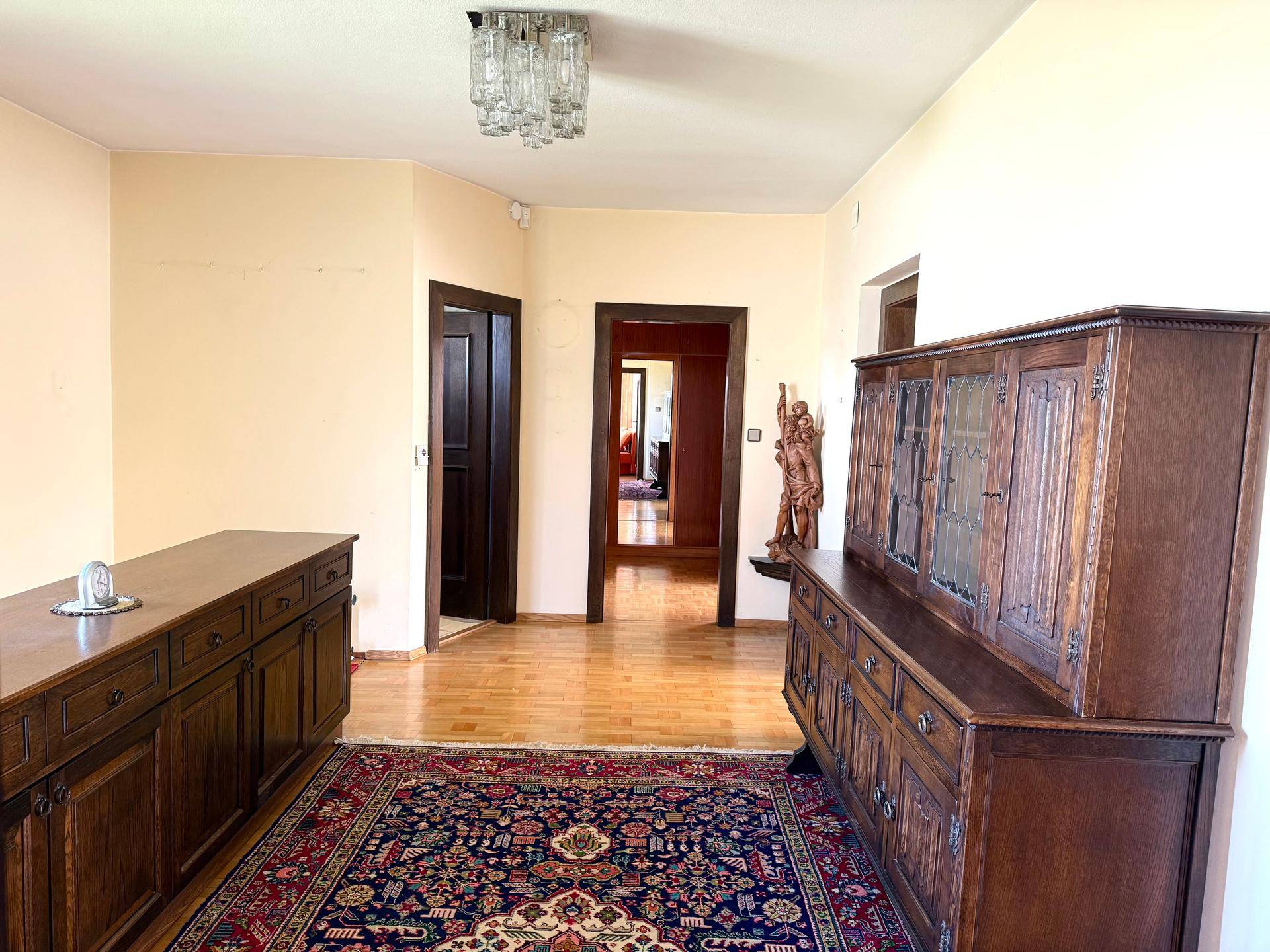 Heller Flur im Obergeschoss mit traditionellen Holzmöbeln und Zugang zu verschiedenen Räumen.