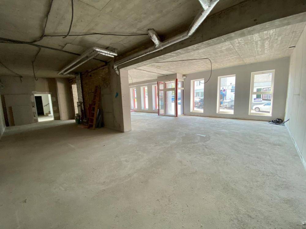 Großer, unfertiger Innenraum mit Betonboden und hohen Decken, bereit für den Ausbau.
